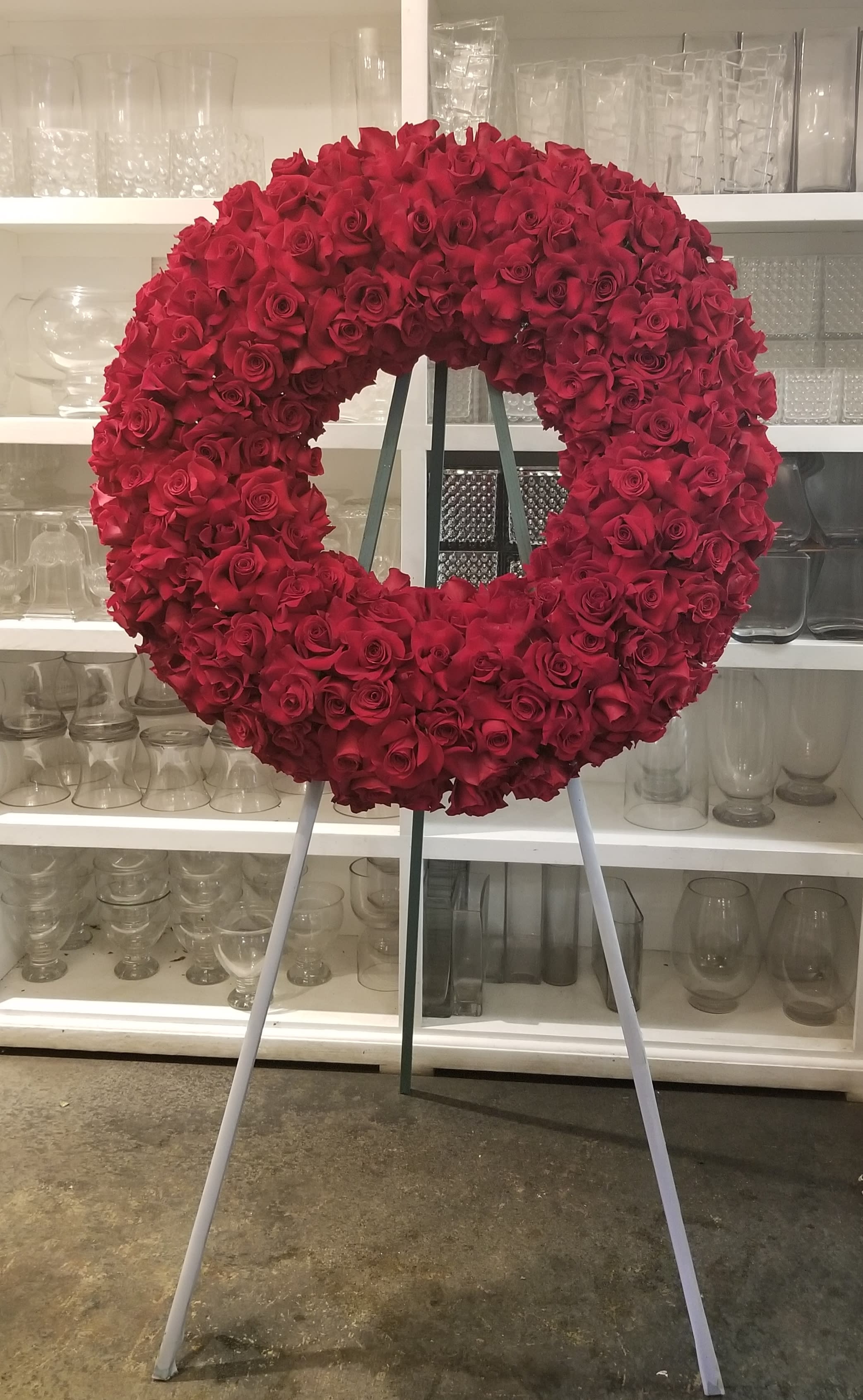 Large circular wreath of red roses on a stand