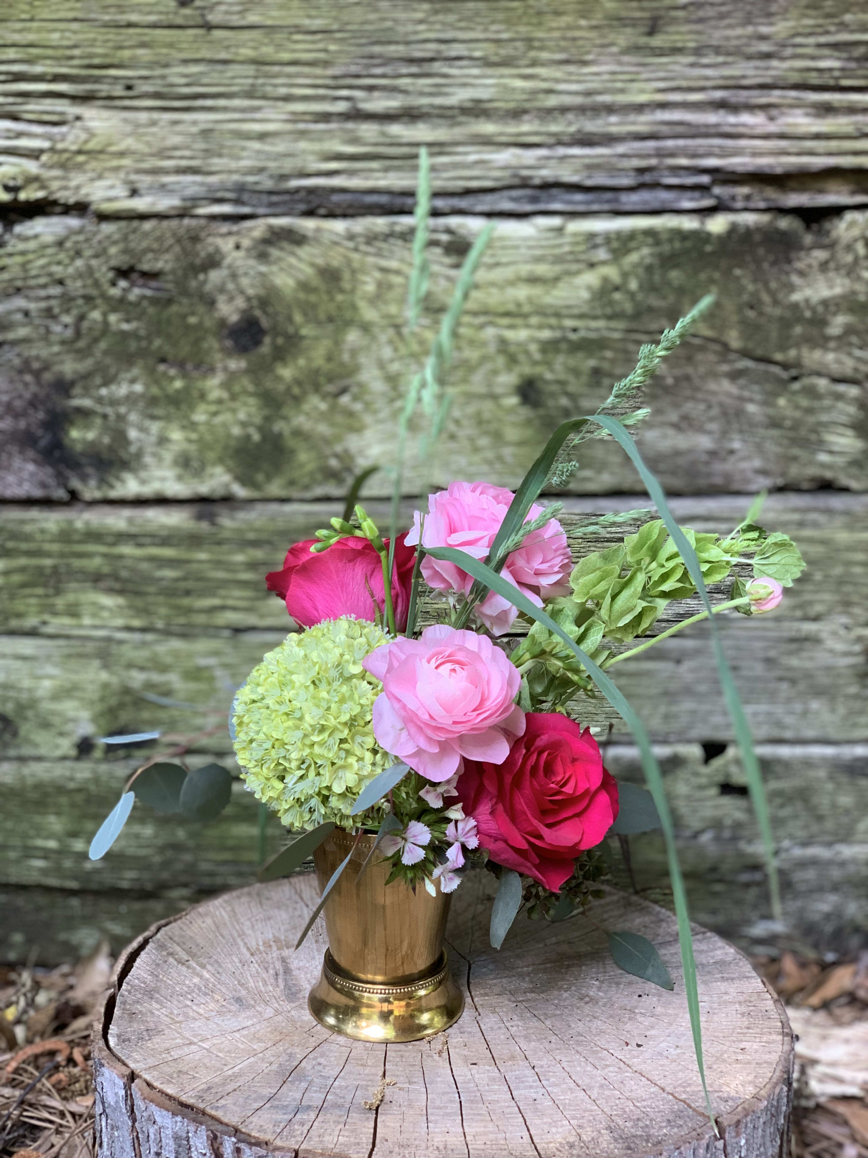 Pink and red roses with green hydrangea in a gold vase