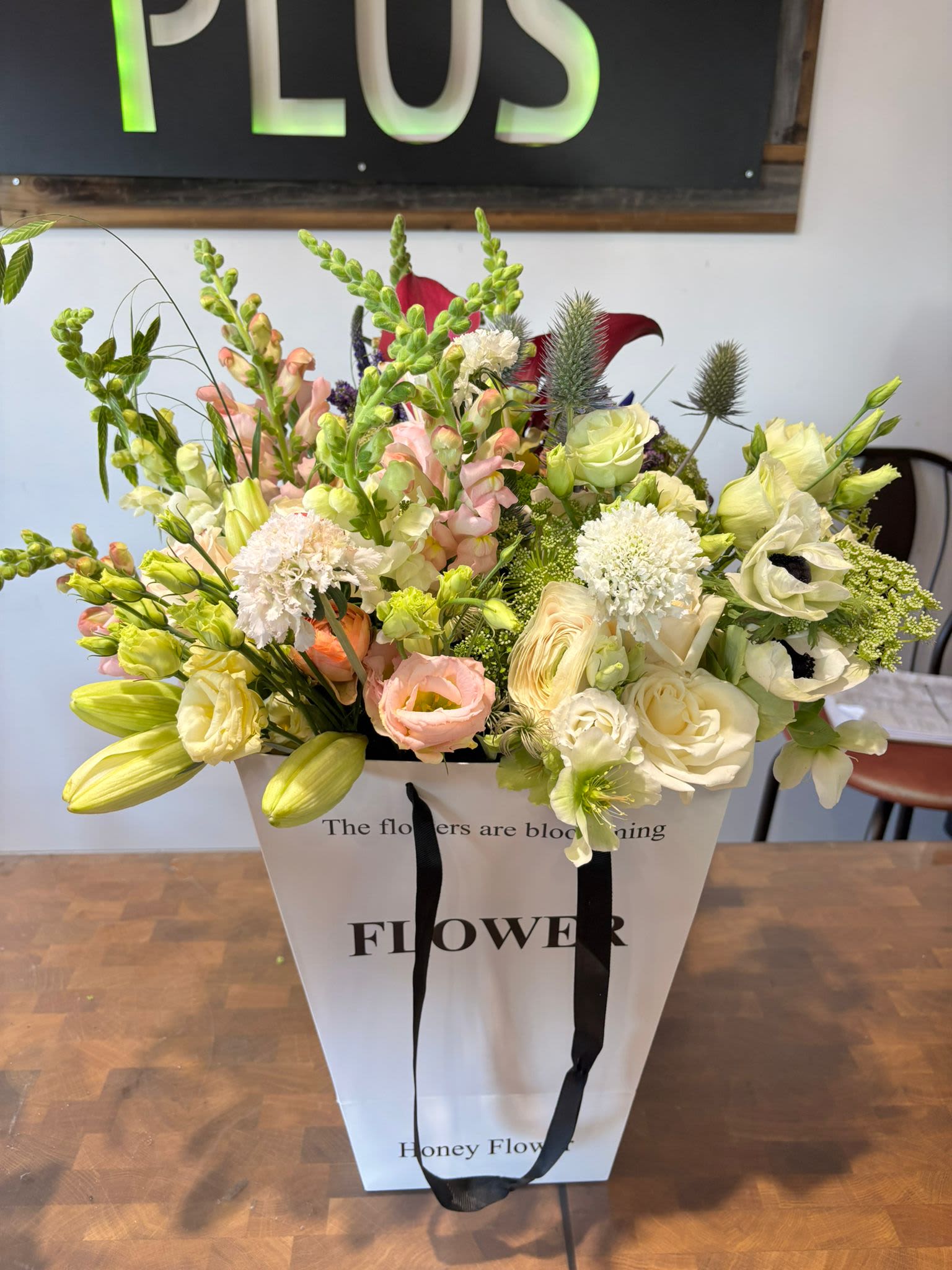 BP6 - Blush &amp; Bloom Flower Bag - It features a sophisticated gathering of cream and blush Lisianthus, fragrant Stock, and lush roses. Delicate and stylish, it’s the ideal gesture for celebrating moments large and small.  Seasonality:  •	Anemones: Peak late Winter through Spring.  Please note: Each piece is unique and uses the freshest seasonal blooms available. While substitutions may occur, we always maintain the beautiful blush and white color palette. 