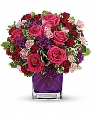 Pink and red rose bouquet in a purple glass vase