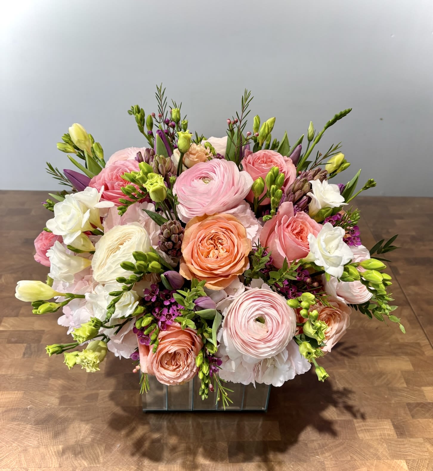 Pink and peach mixed flower arrangement in a glass vase