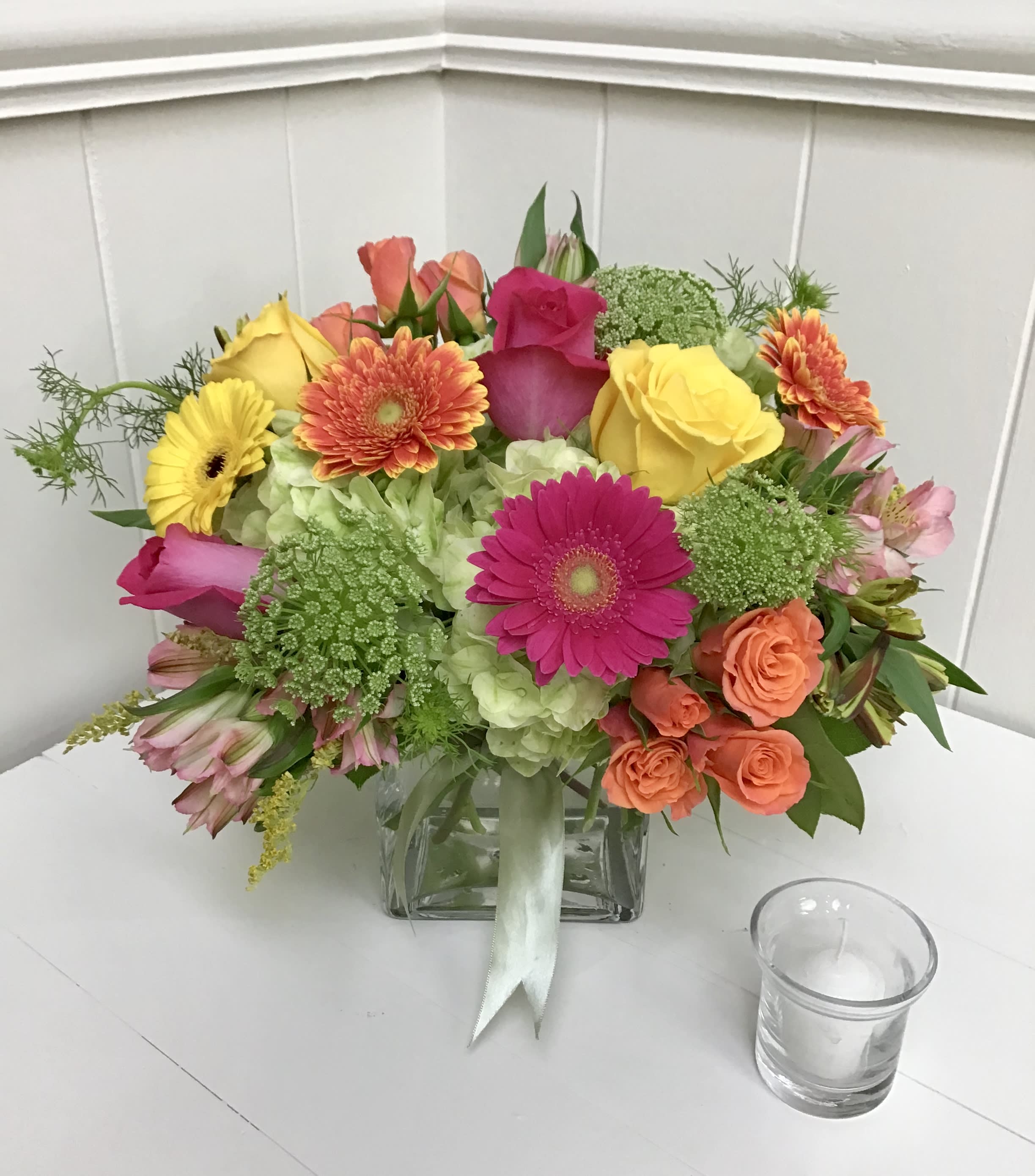 Colorful bouquet of roses, gerbera daisies, and hydrangeas in a glass vase