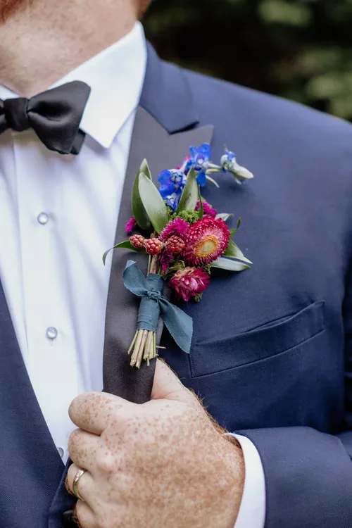 Formal Boutonnière (adaptable color) - This is our classic Papillon boutonnière. We gather a fun, unique, and interesting selection of foliage and blooms and wrap them with a matching ribbon complete with pins to attach to clothing. These are wonderful for prom and other special events.   When ordering, please leave us a note under “special instructions” with the desired color palette for your boutonnière.  And your preferred ribbon color   This item is pickup only between  — please let us know in the notes what time you’ll be picking up. 