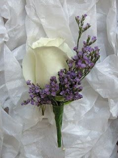White rose boutonniere with purple filler flowers
