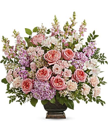 Pink roses and mixed pastel flowers arranged in a dark vase