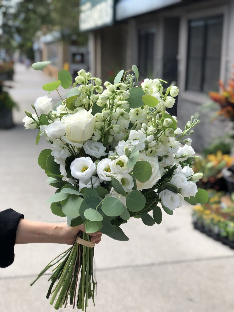 White bouquet with roses and lisianthus, accented by round eucalyptus leaves