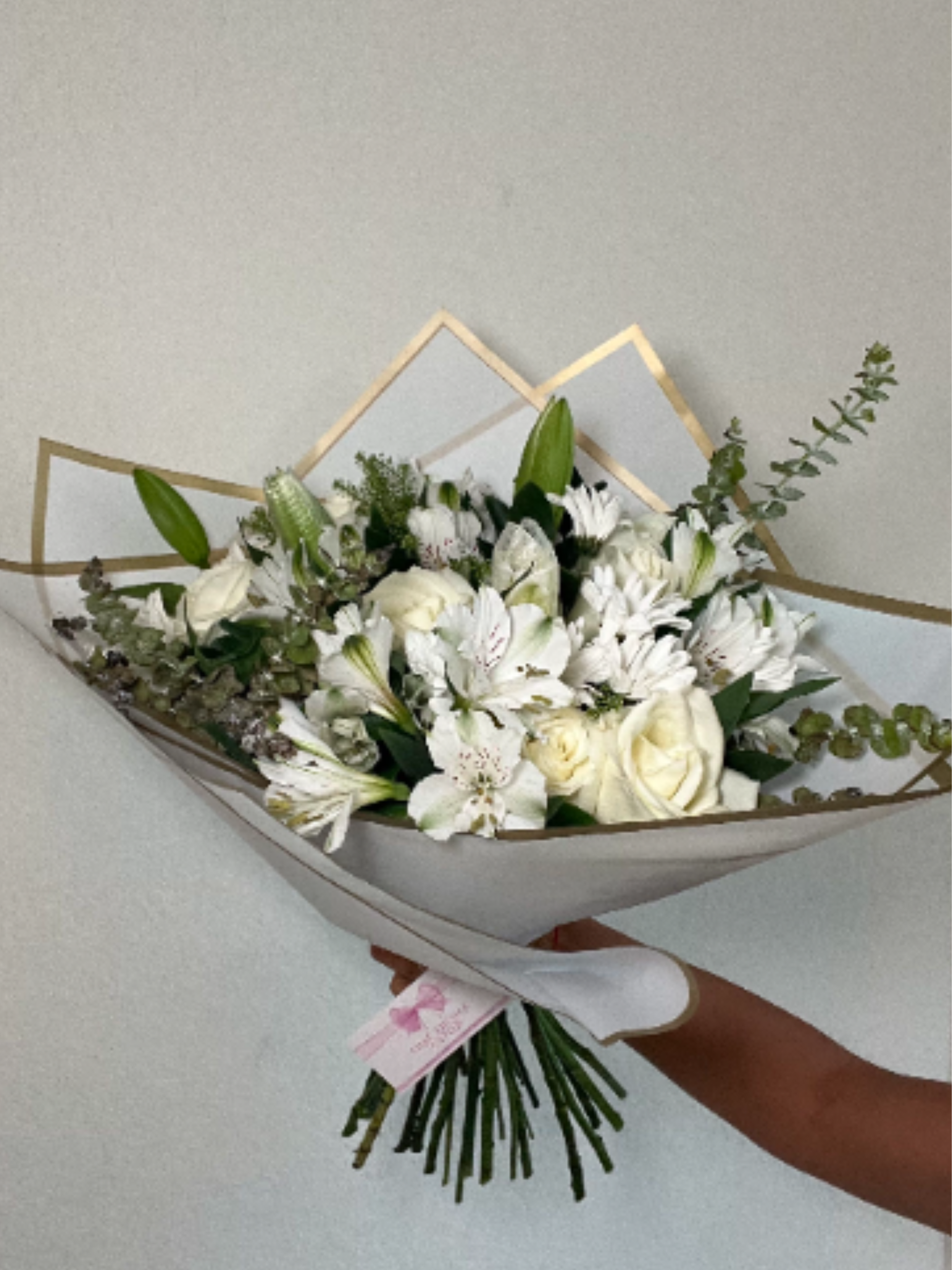 White Elegance - A timeless expression of purity and sophistication, White Elegance brings together the classic beauty of white roses, the graceful presence of white lilies, and the soft charm of white daisies. Designed with a lush mixture of fresh greenery, this bouquet creates a serene and luxurious look that brightens any space.
