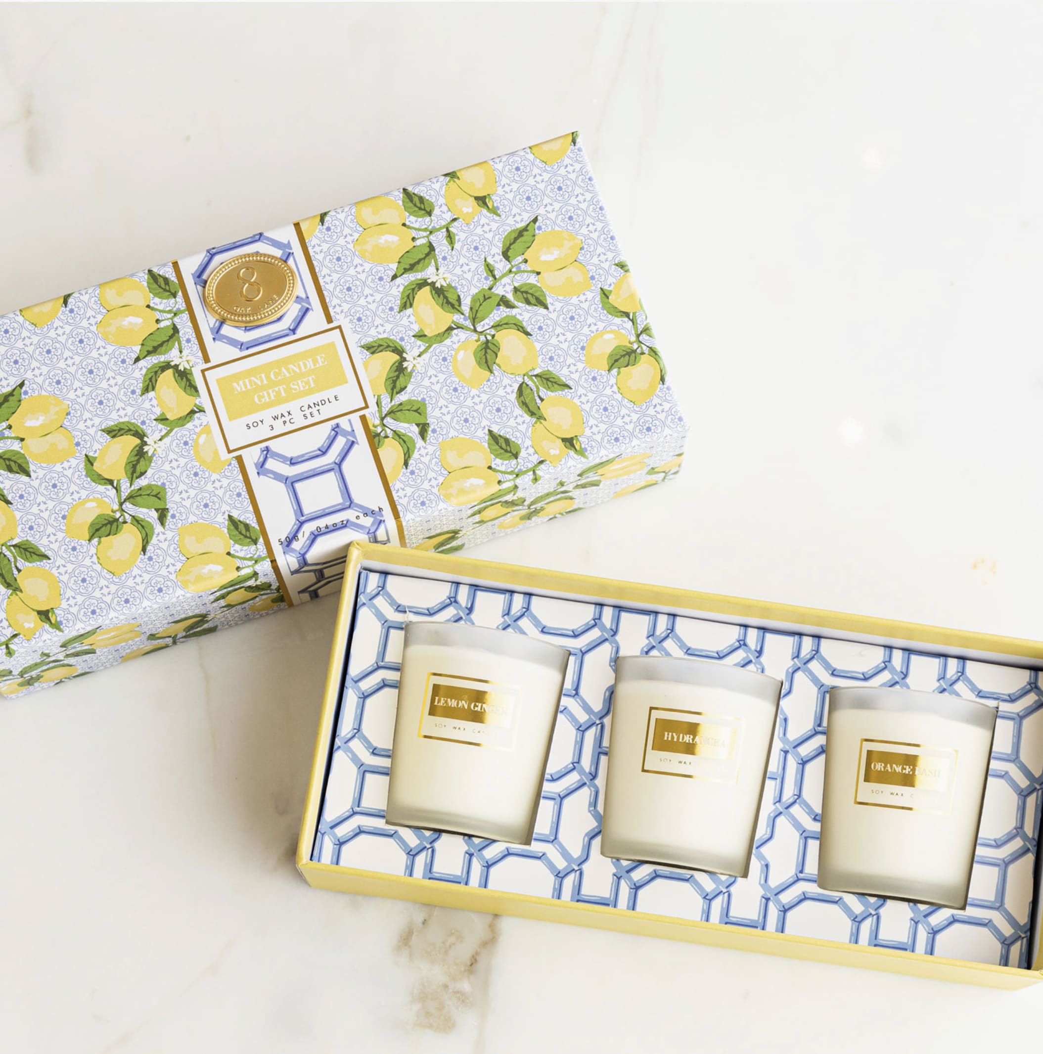 Two boxed mini candle gift sets with lemon-patterned packaging and three candles visible