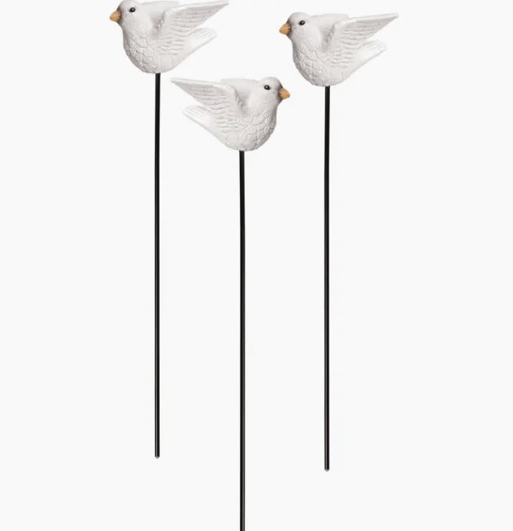 Three white bird garden stakes with long black rods