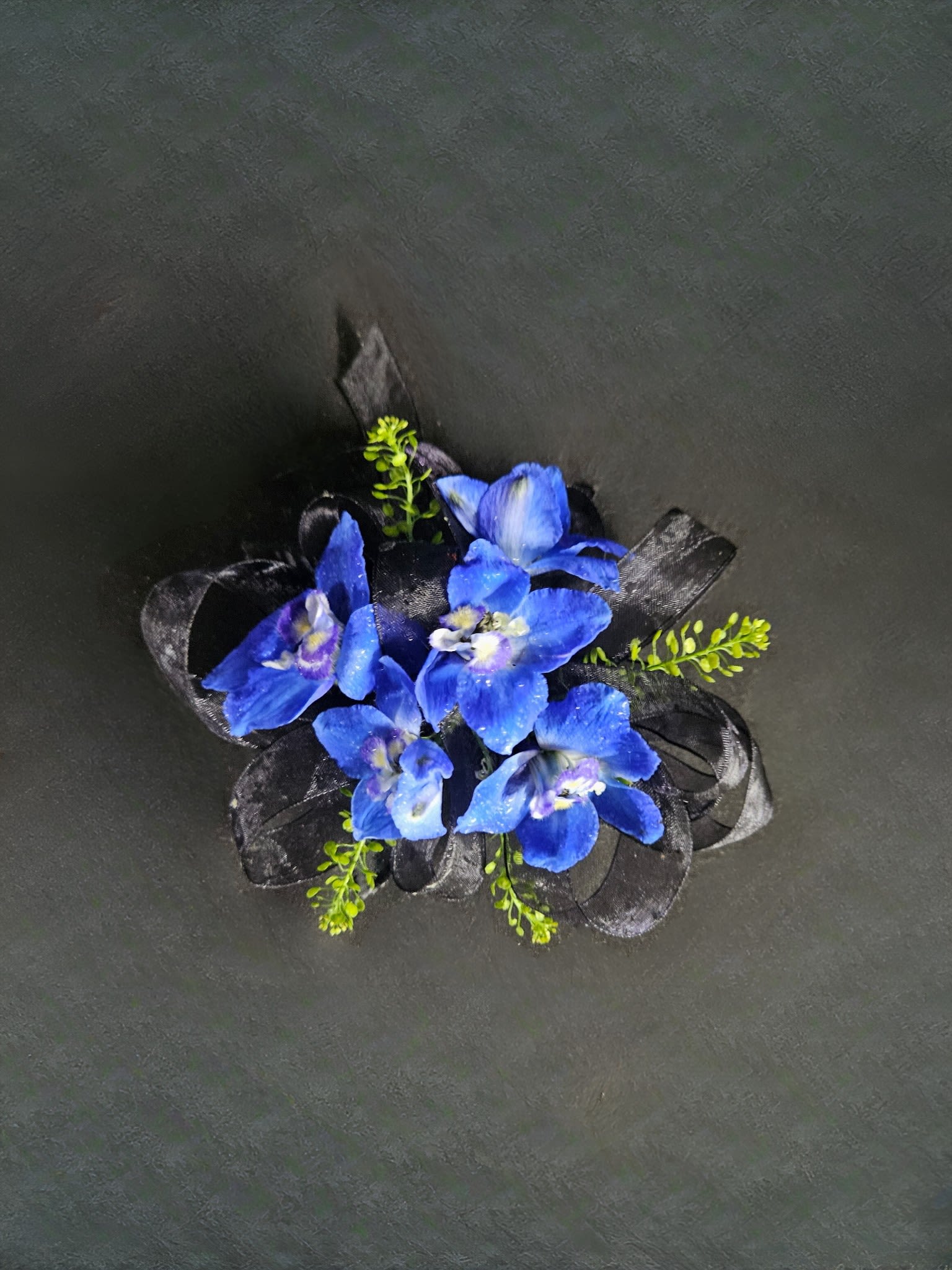 Dark Blue Delphinium Corsage - A naturally blue flower that will compliment any outfit. The only flower color option for this boutonniere is dark blue. Please select the wristlet color and up to 2 ribbon colors from the add-on selections you would like included. (Please do not select any of the flower color options)