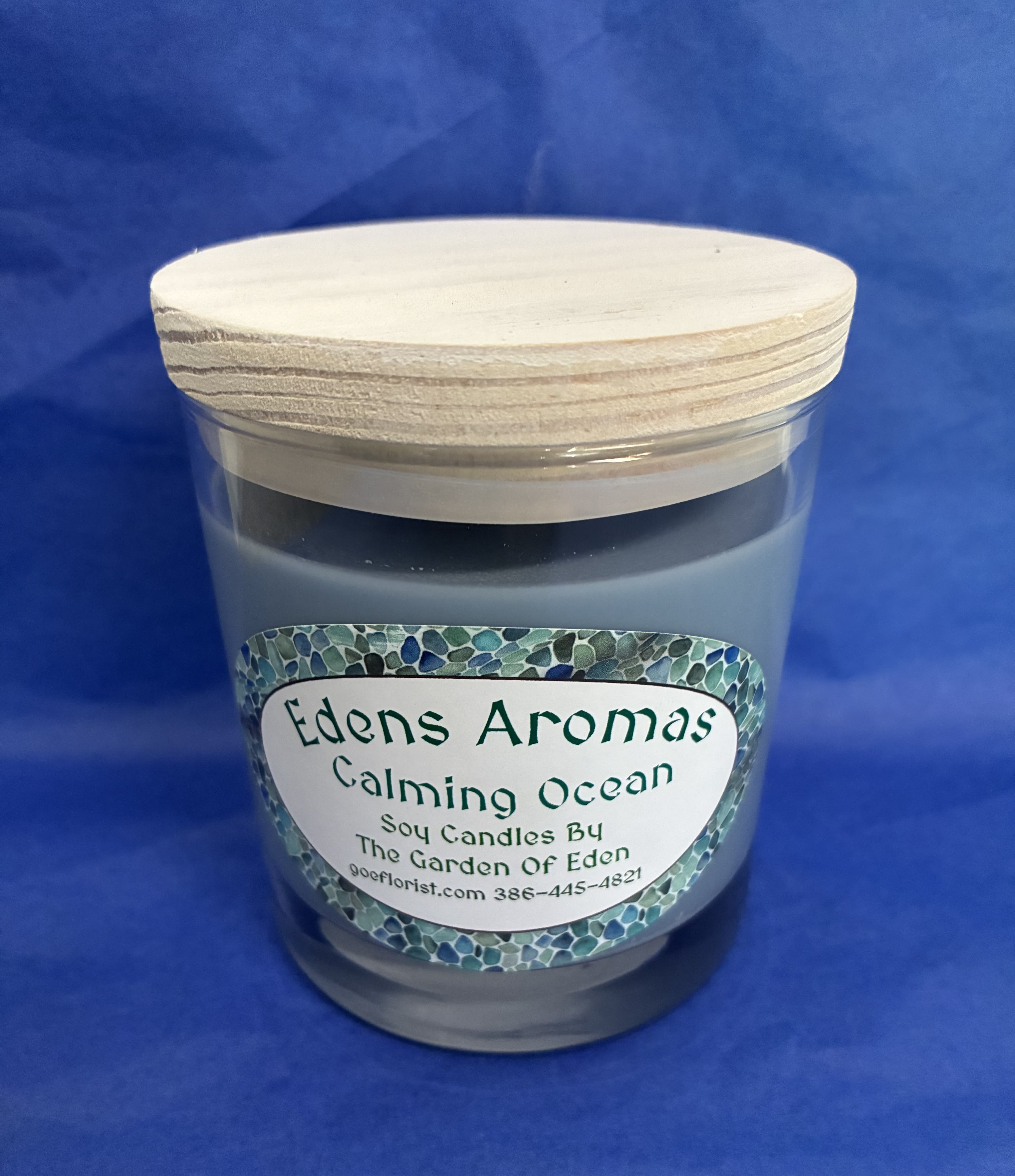 Calming Ocean scented soy candle in a glass jar with a wooden lid