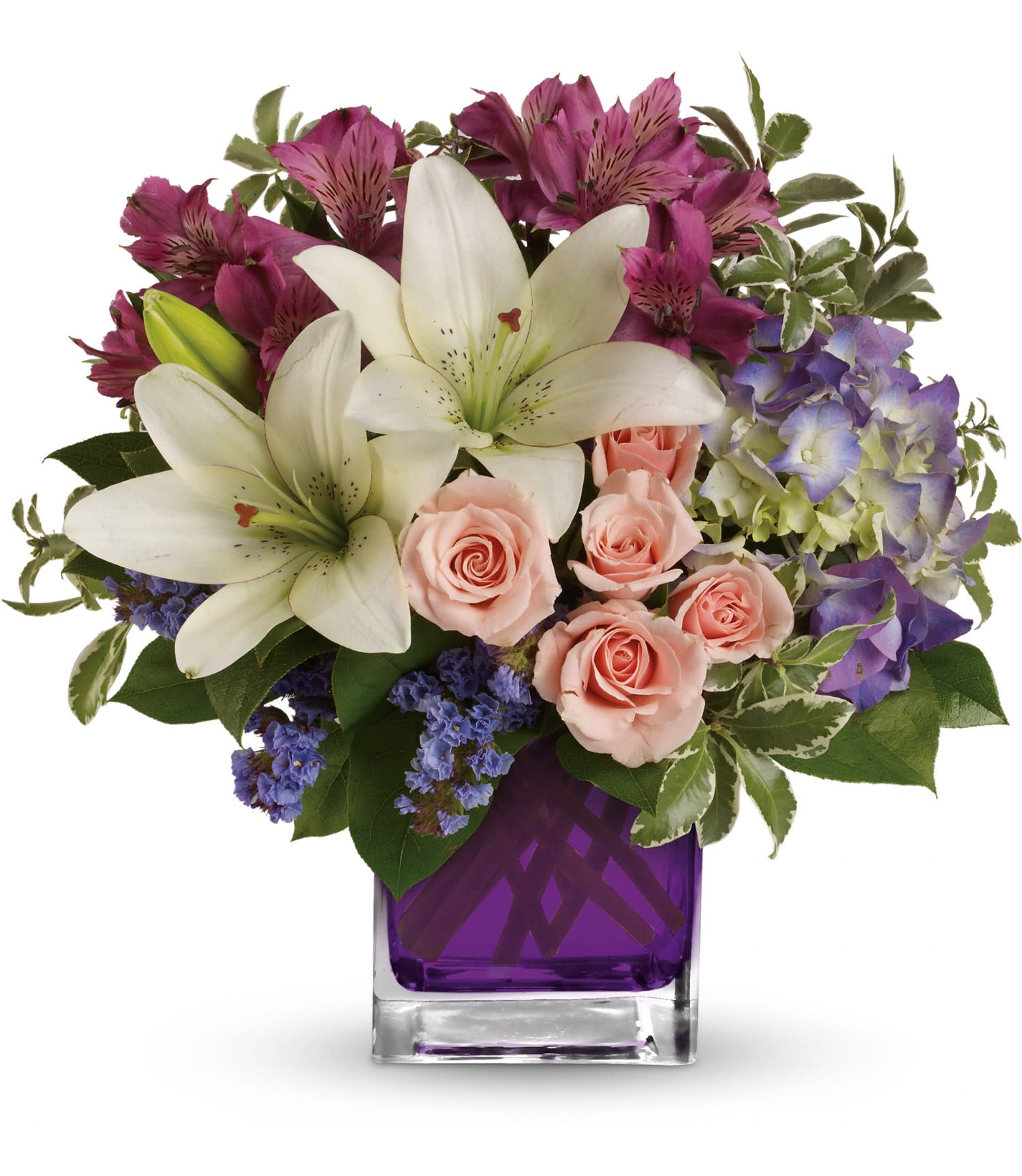 Bouquet of white lilies, pink roses, and purple flowers in a purple glass vase