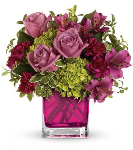 Pink roses and magenta flowers in a square glass vase