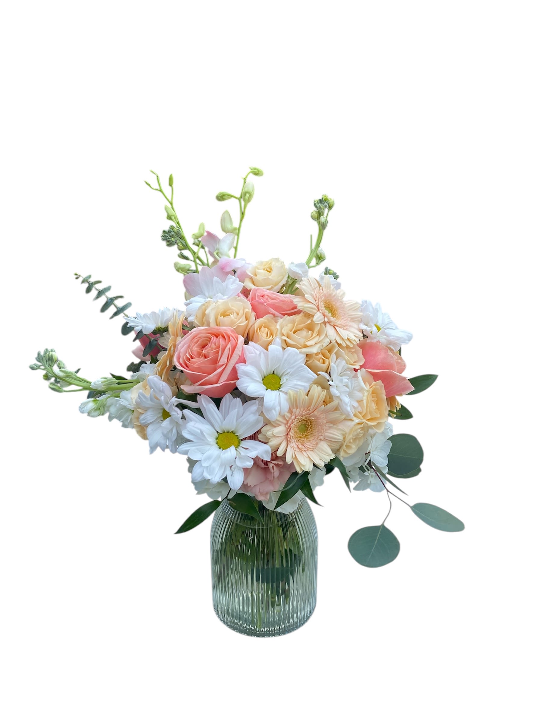 Pastel bouquet of peach roses, white daisies, and soft gerbera in a ribbed glass vase