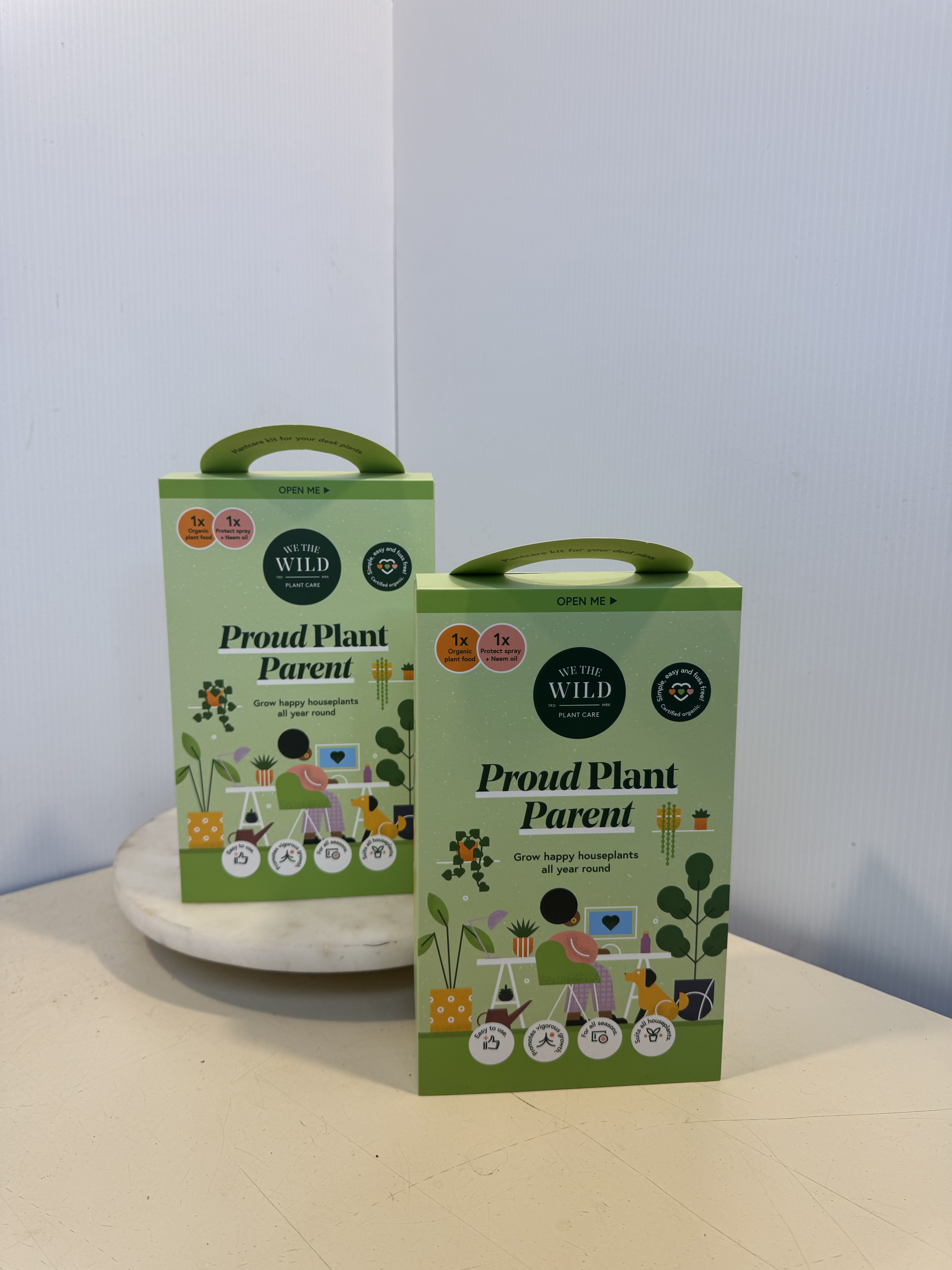 Two green plant care gift boxes on a table
