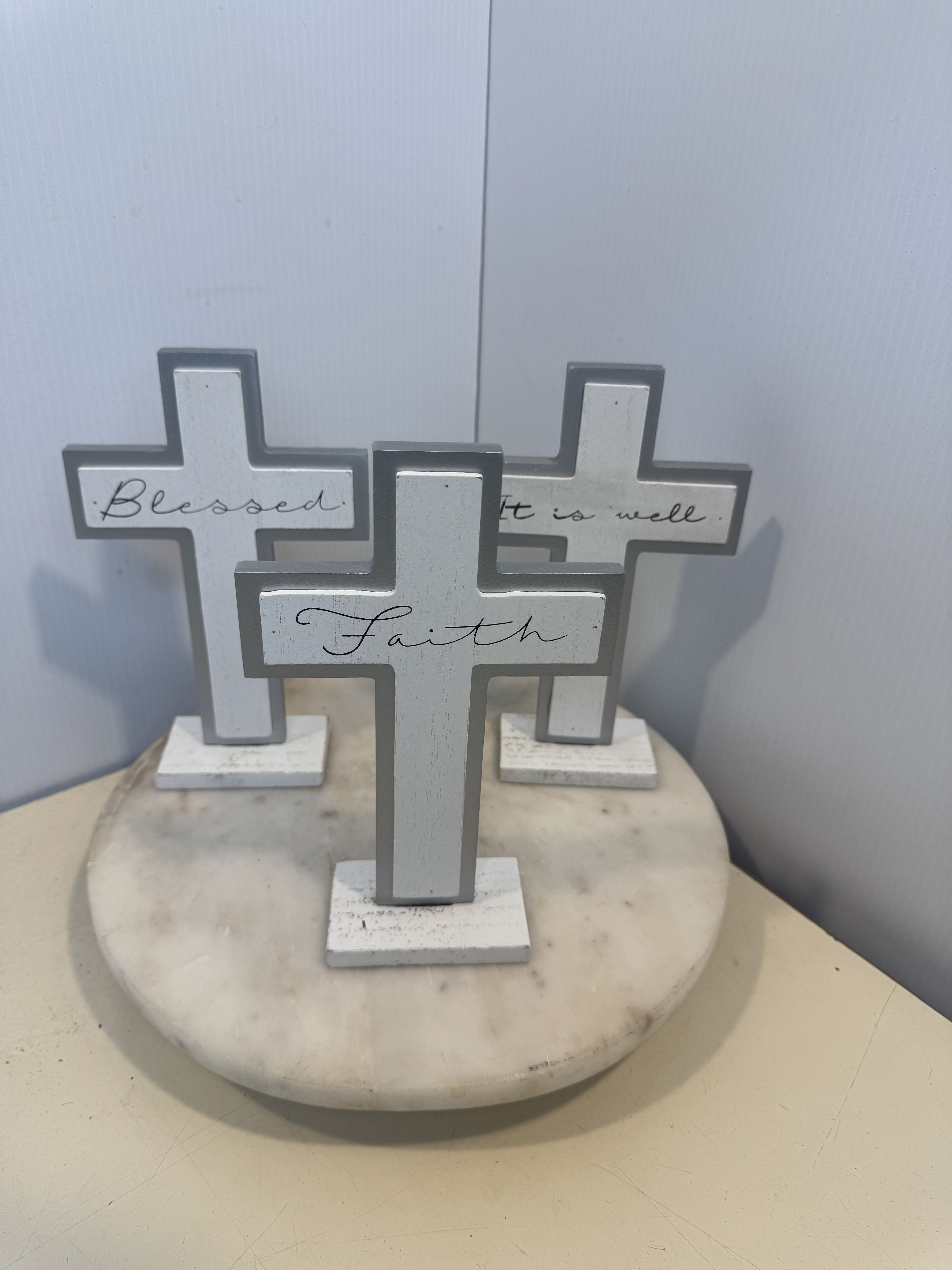 Three decorative cross signs on a round marble base