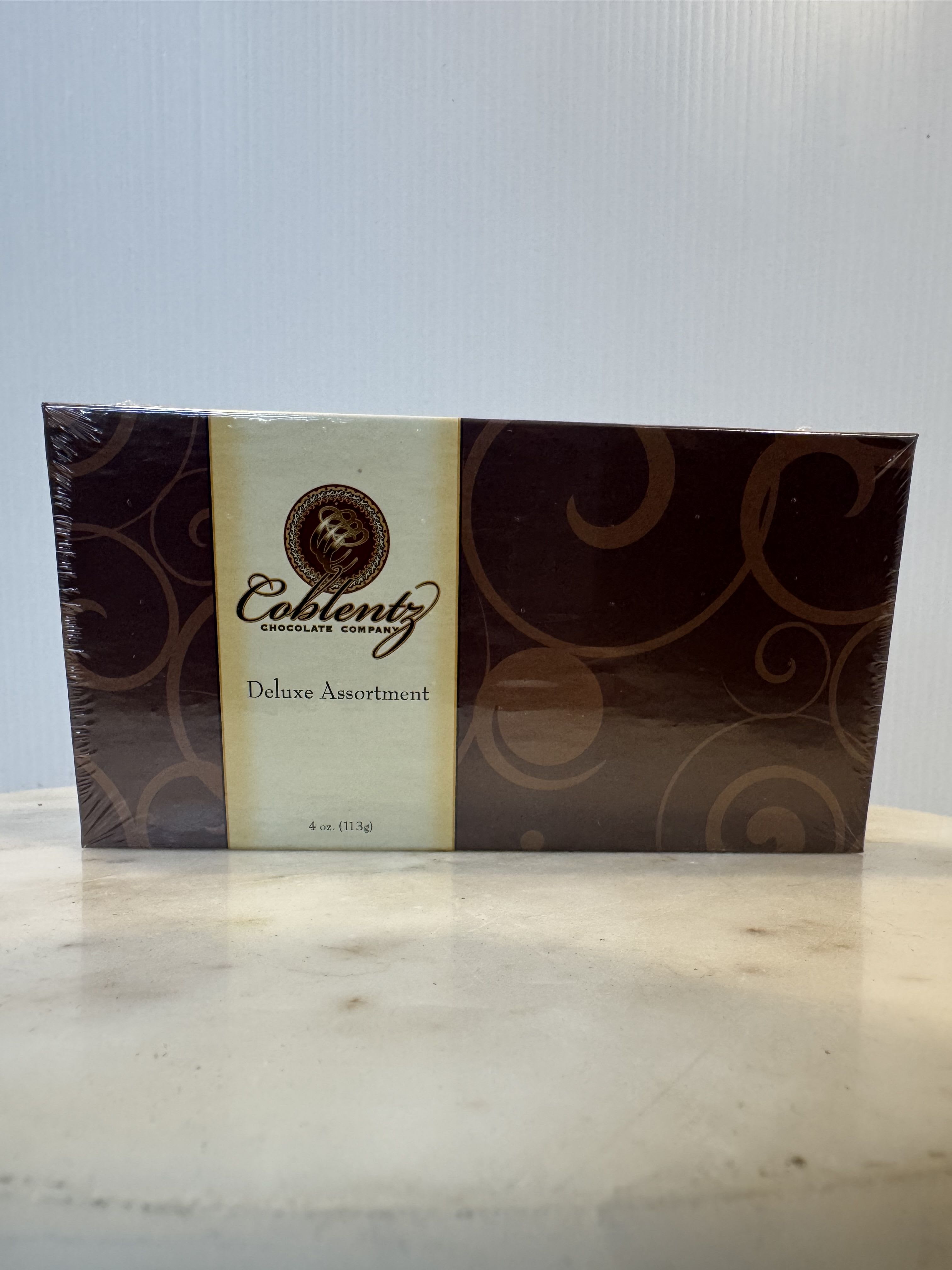 Box of deluxe assorted chocolates in brown and cream packaging