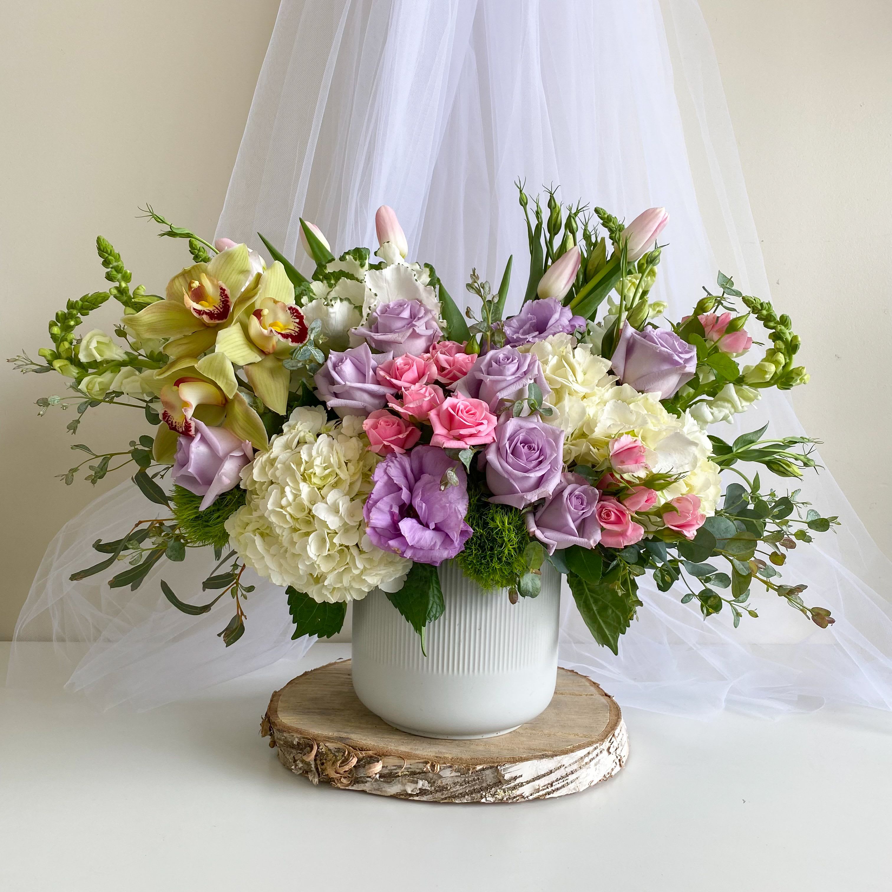 Lavender and pink floral arrangement in a white vase