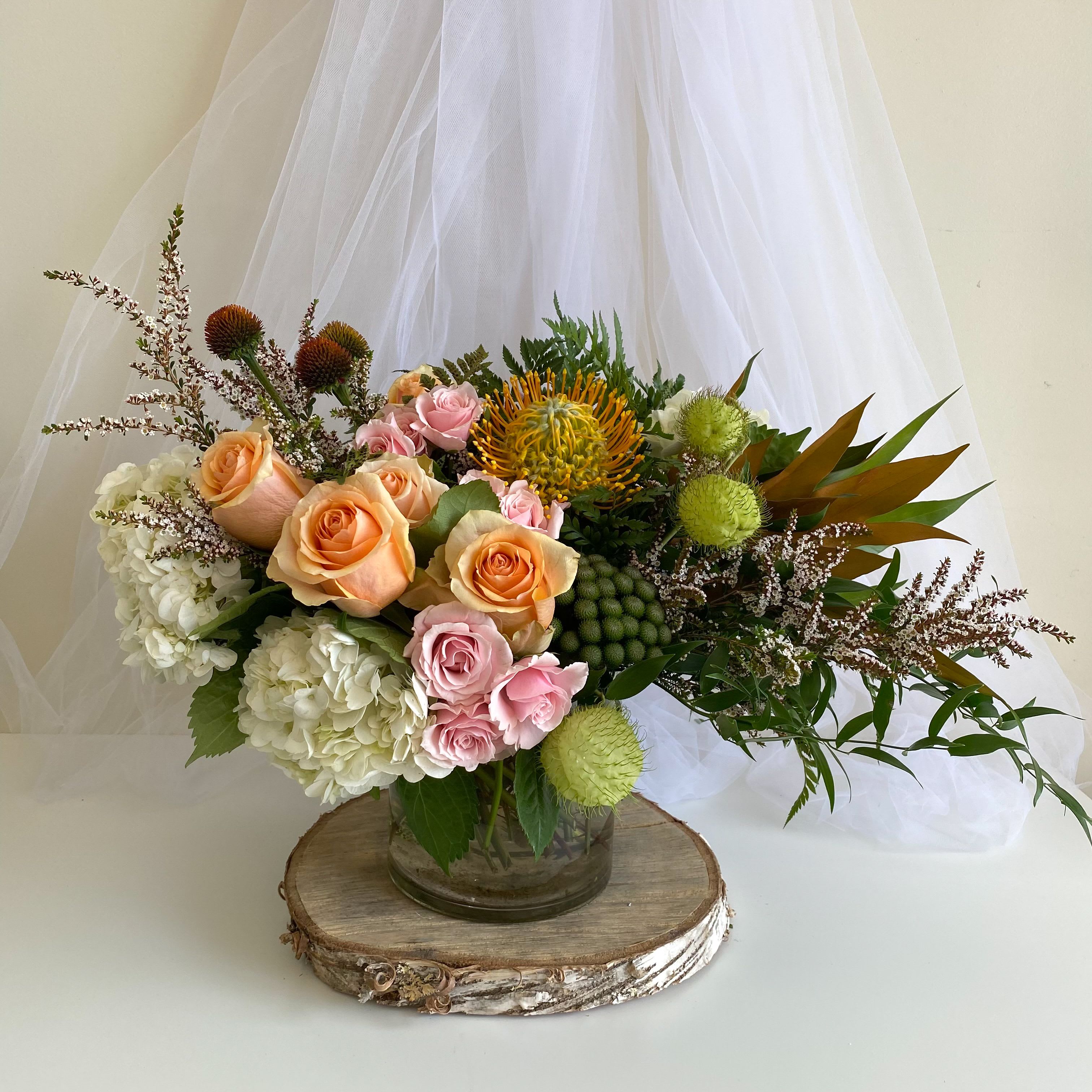 Mixed bouquet of peach and pink roses in a glass vase