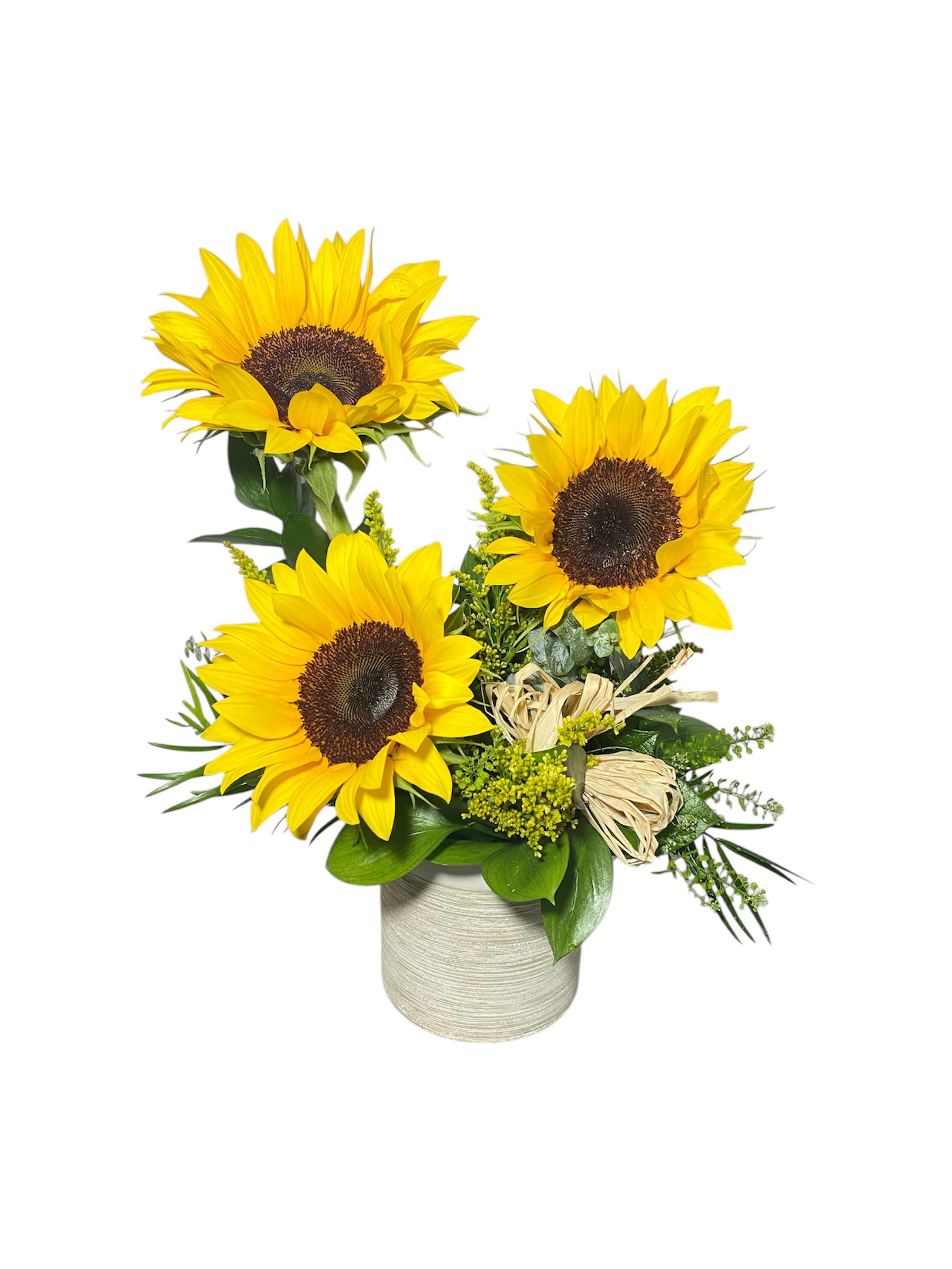 Three sunflowers arranged in a vase with greenery and raffia accents