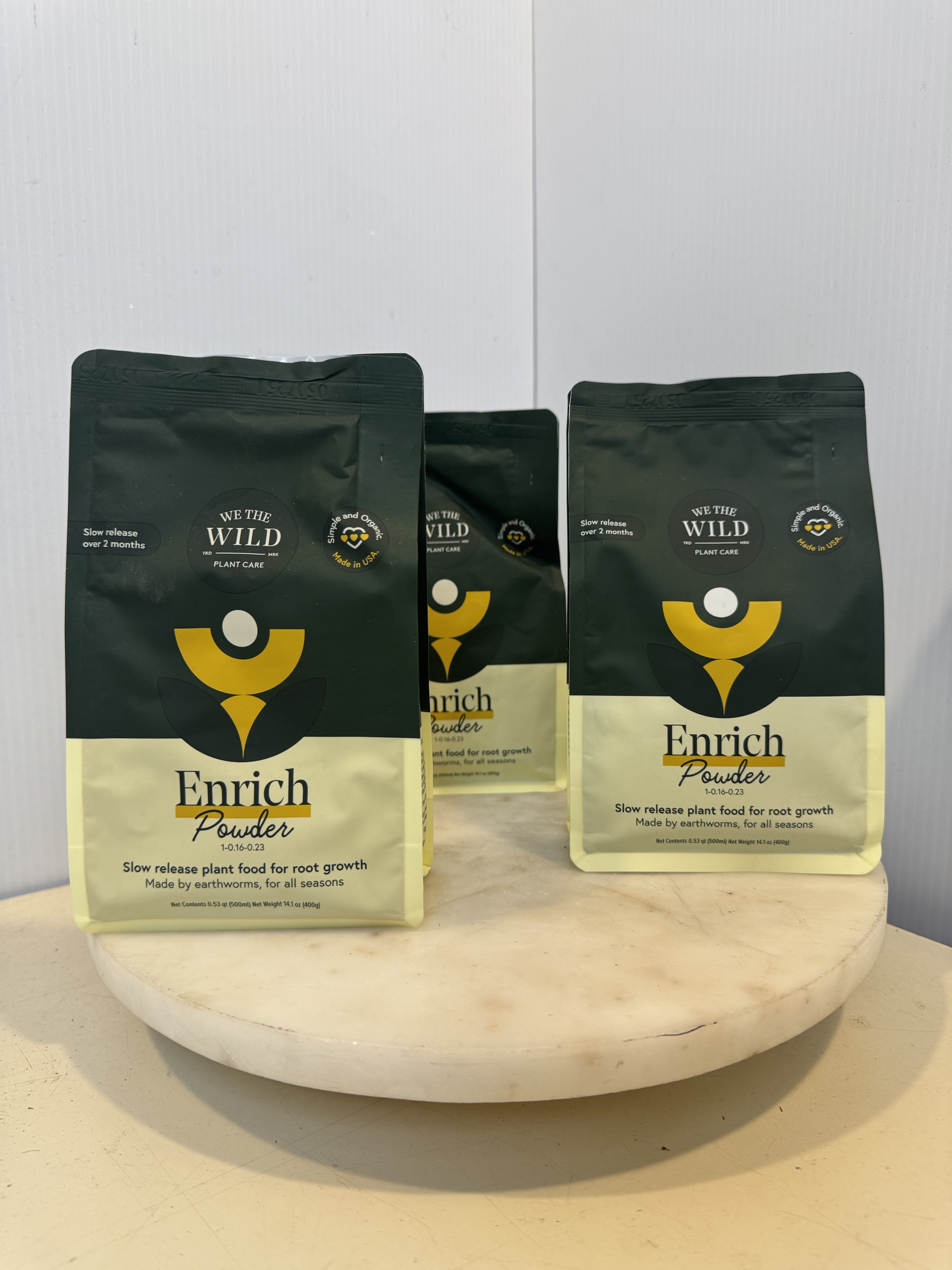 Three bags of plant food on a round pedestal