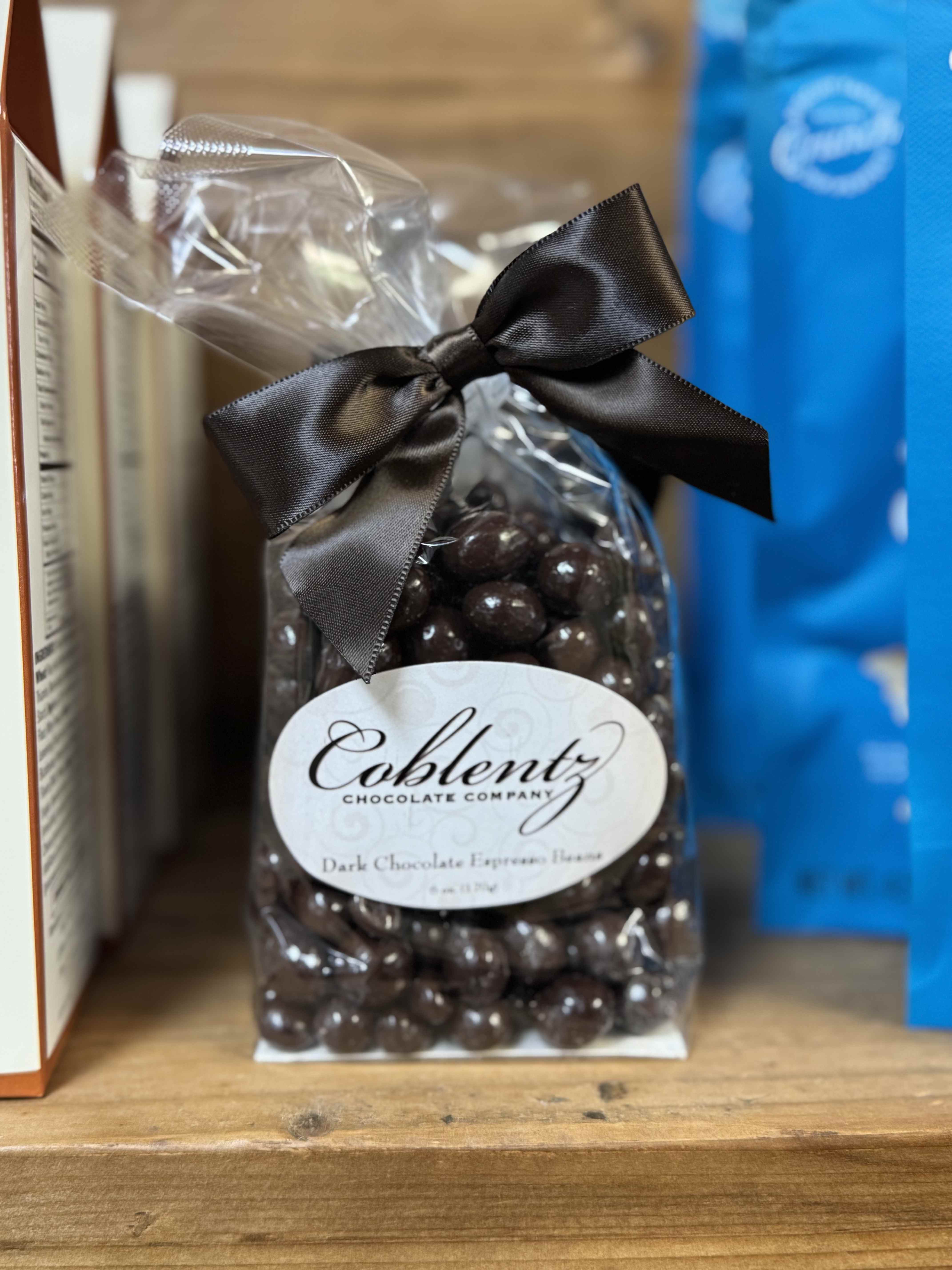 Bag of dark chocolate espresso beans tied with a black ribbon