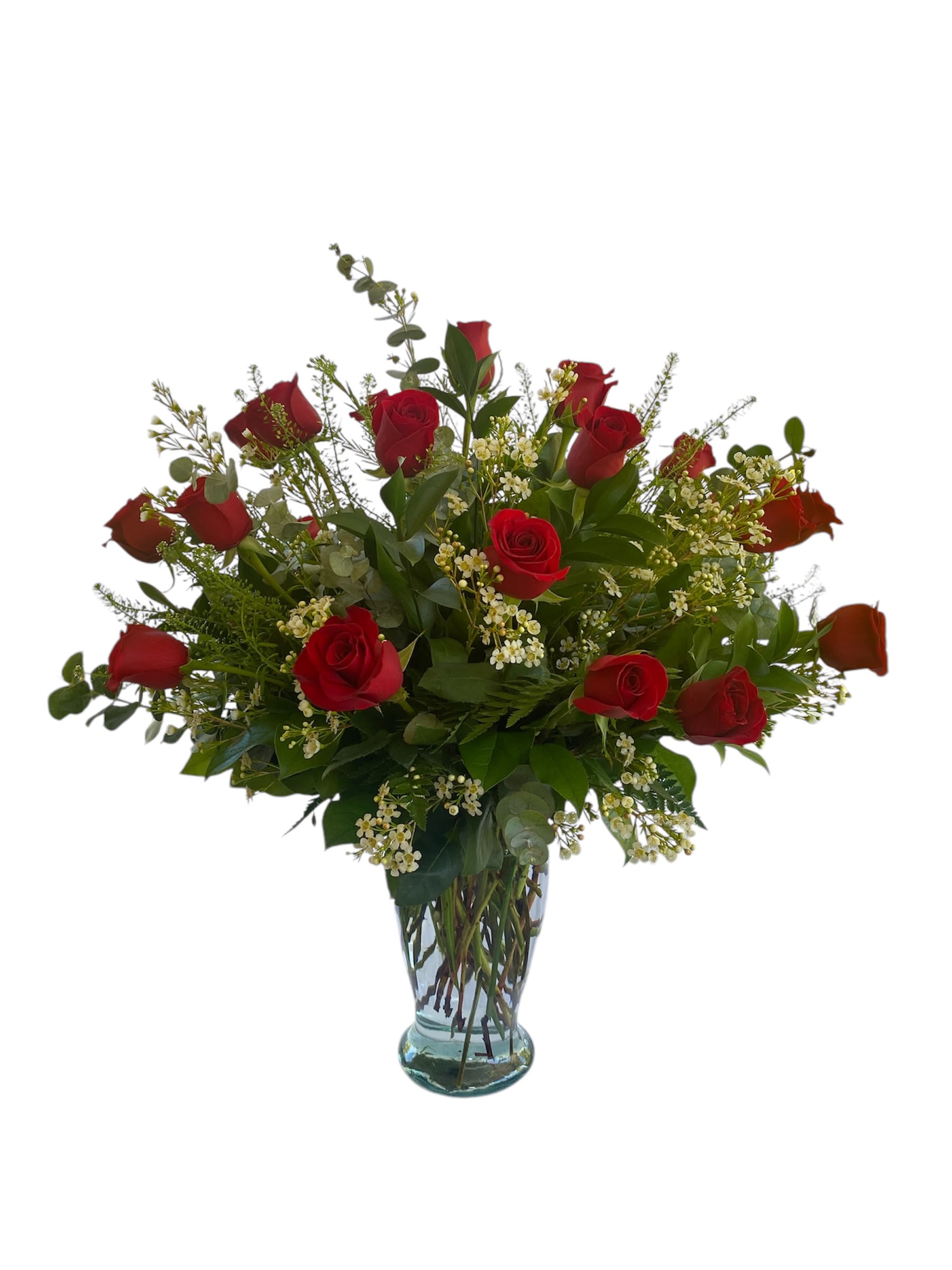 Tall arrangement of red roses with small white blooms in a clear glass vase