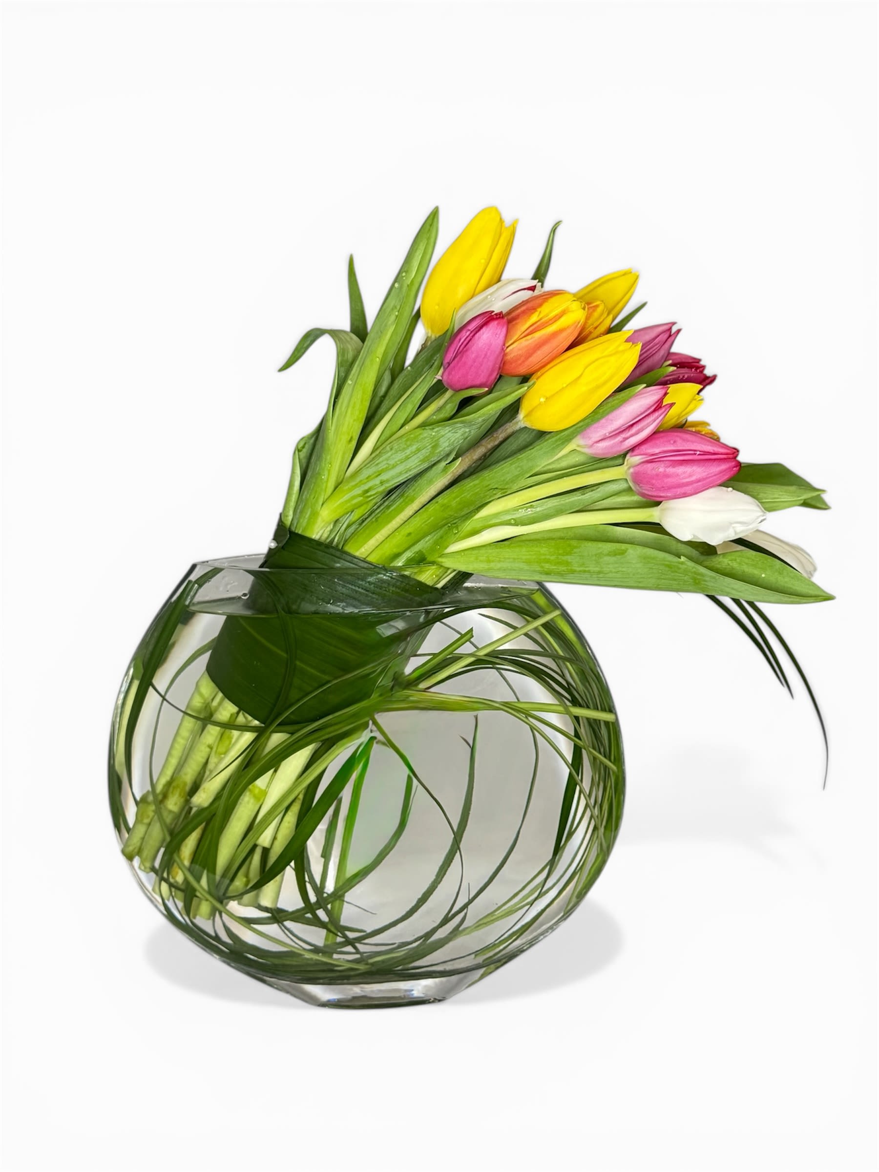 Tulip Garden Love - A graceful cascade of 20 colorful tulips gathered in a modern glass vase, accented with delicate greenery. 