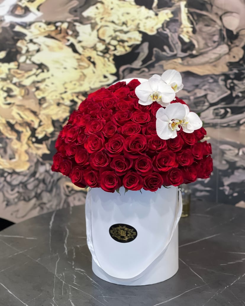 Red rose arrangement in a white hatbox with white orchids