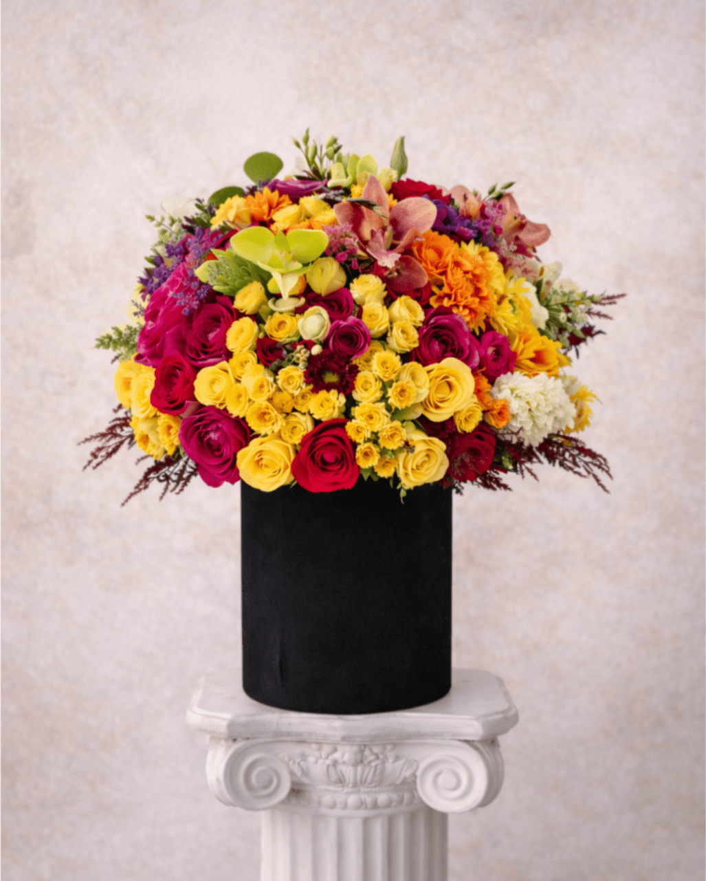 Bright mixed bouquet in a black cylindrical vase