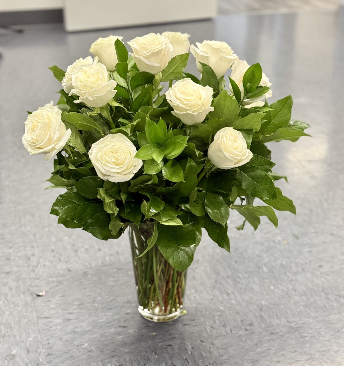 White roses arranged in a clear glass vase