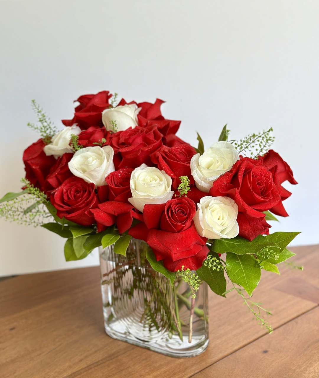 Red and white roses arranged in a clear glass vase