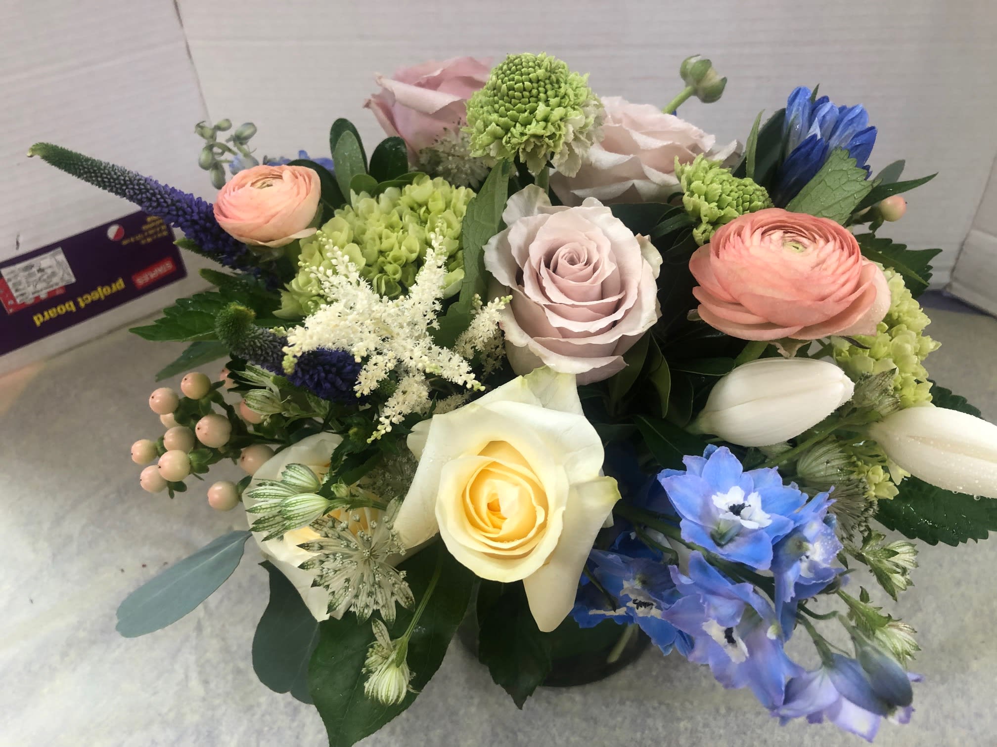 Mixed bouquet with roses, ranunculus, and blue flowers