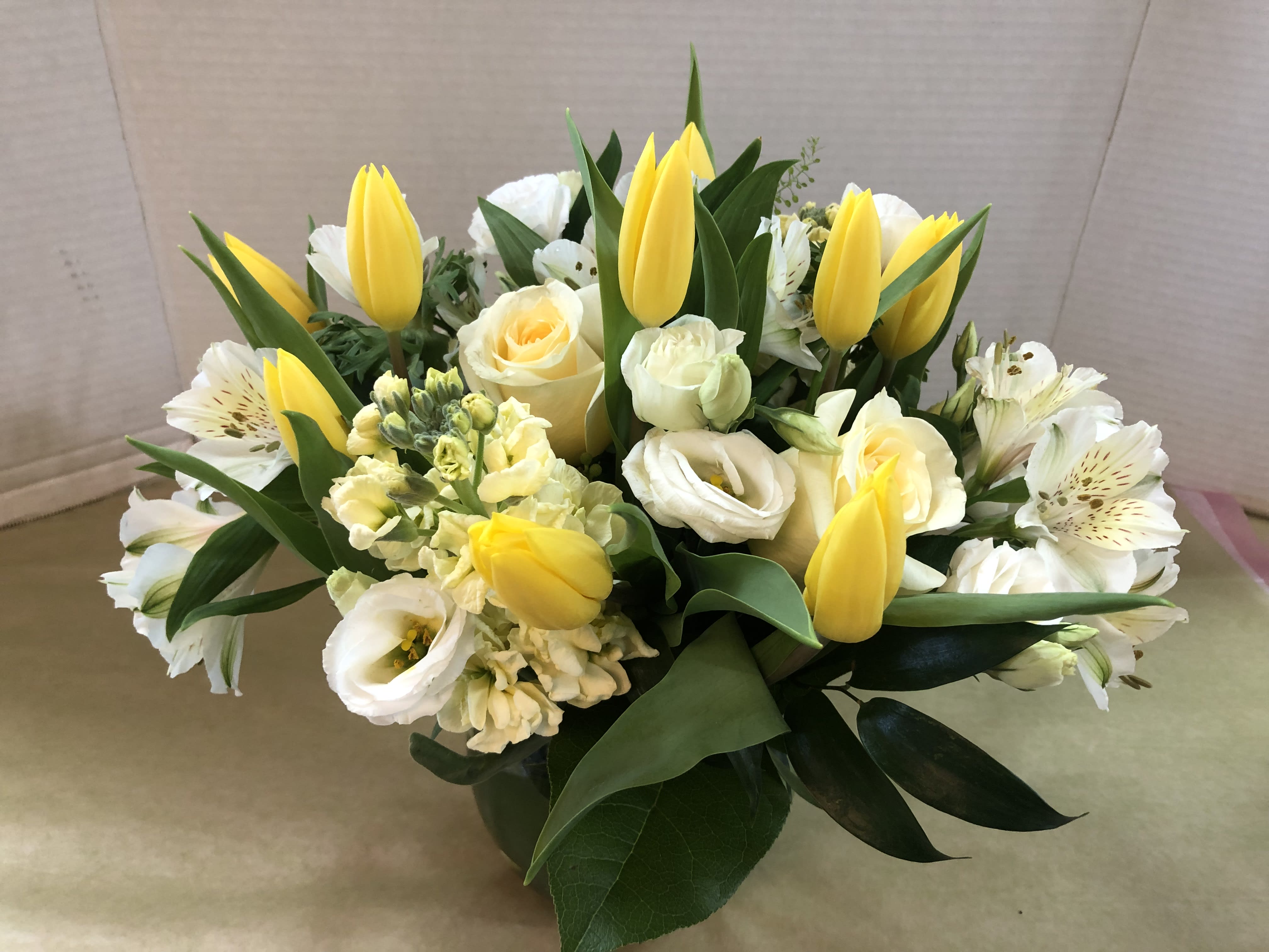 Bouquet of yellow tulips and white flowers with greenery