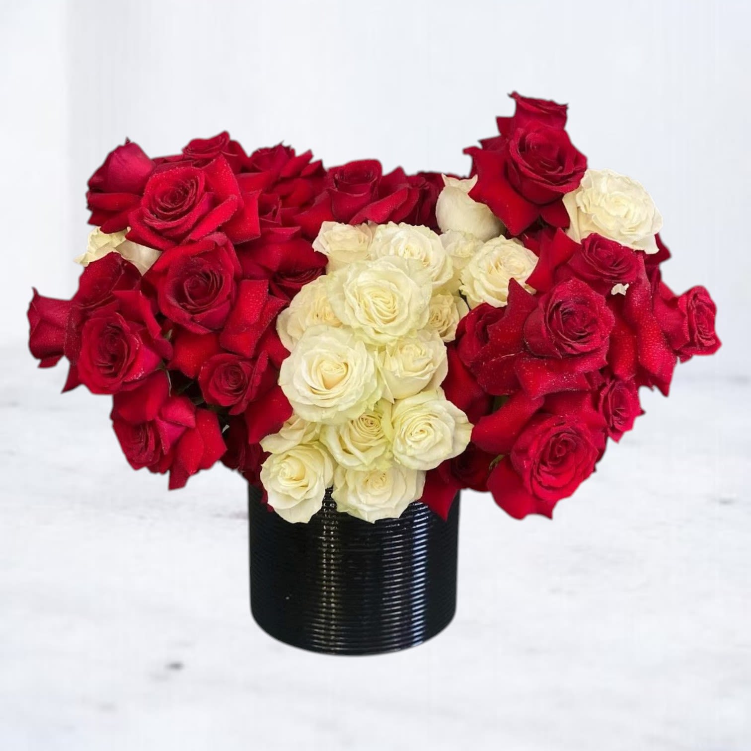 Red Code - A bold and modern take on classic romance, this luxury rose arrangement features 36 red roses and 18 white roses designed in a clean, structured, color-blocked style. The high-contrast design and premium rose count create a full, impactful look that stands out from traditional rose bouquets.  Perfect for anniversaries, Valentine’s Day, or romantic flower delivery in Magnolia, TX and surrounding areas, this arrangement is designed to make a lasting impression.