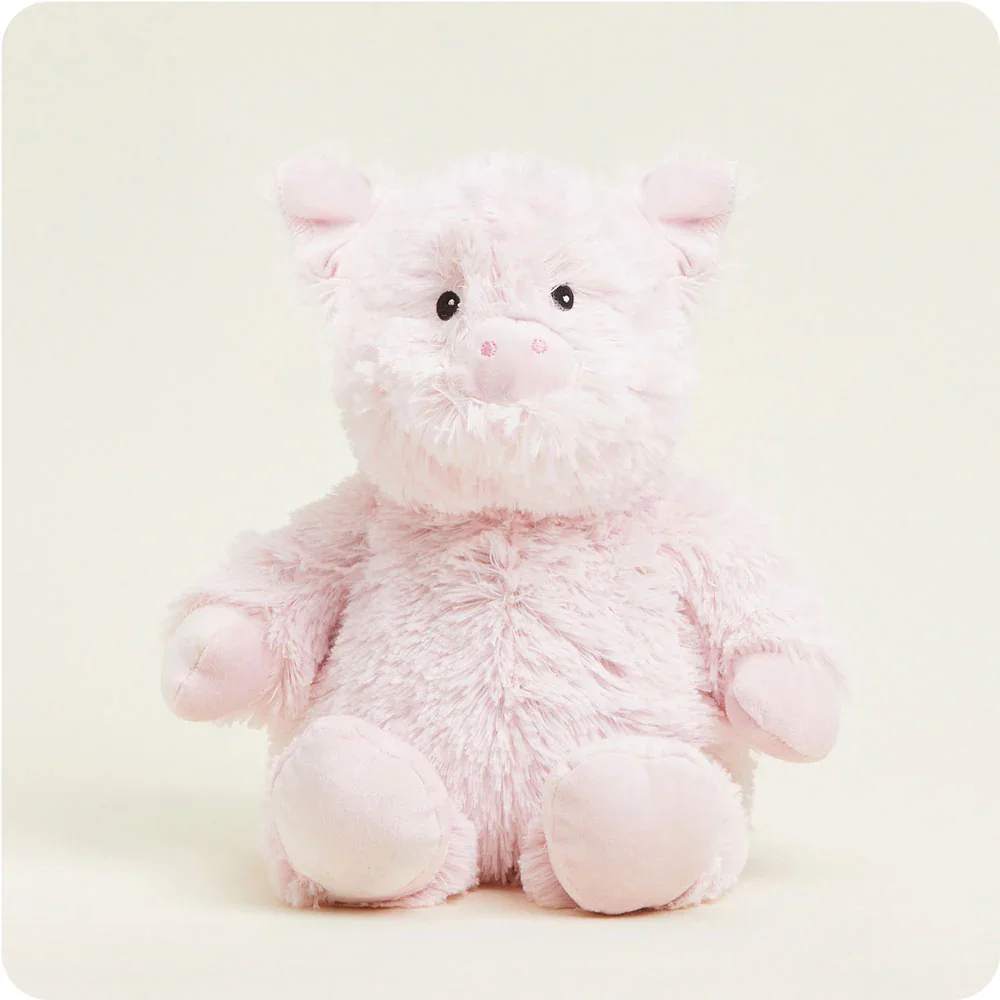 Pink plush pig toy sitting against a plain background