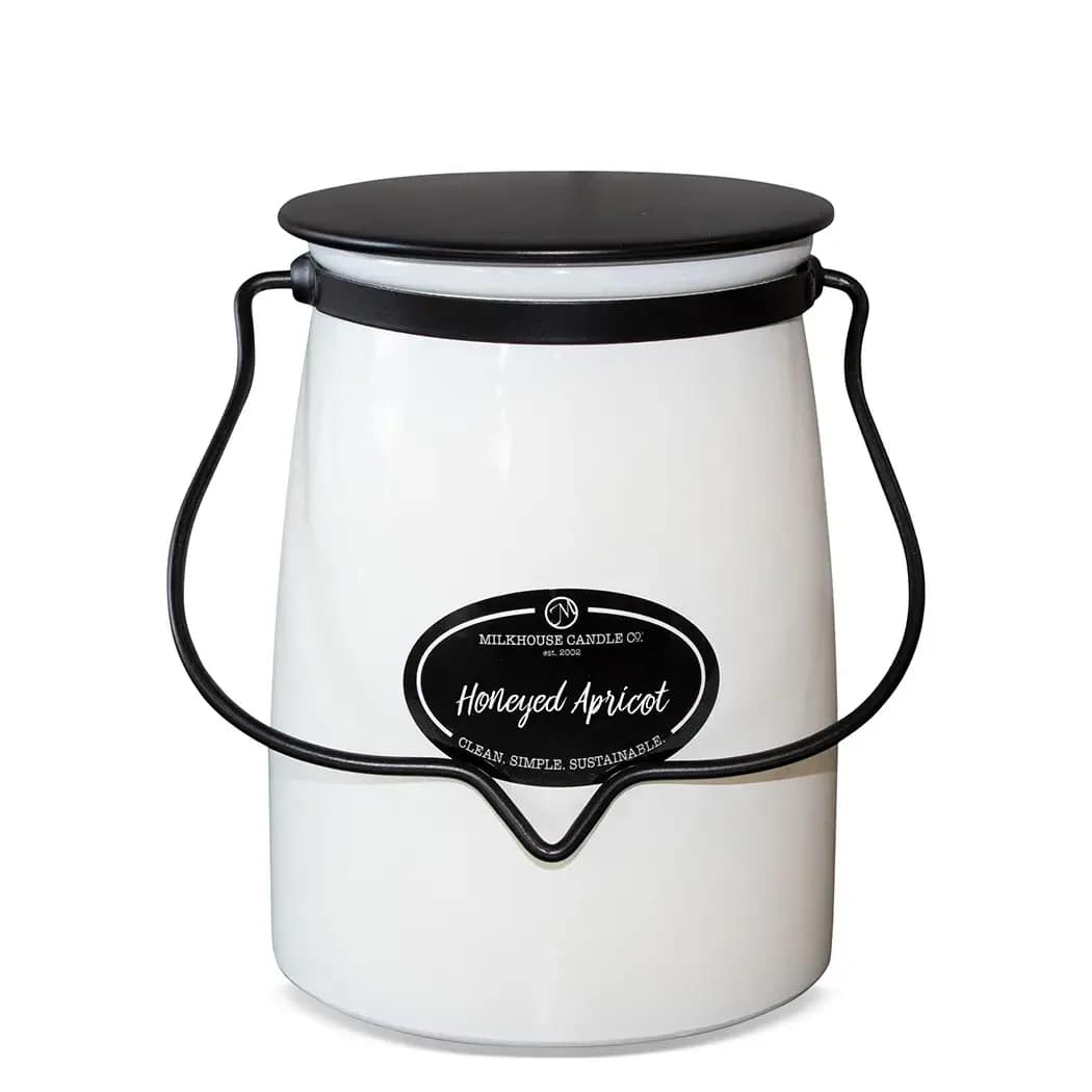 White candle in a black-handled metal bucket with a lid