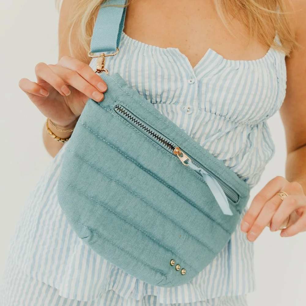 Jolie Puffer Bum Bag Light Denim  - * Adjustable waist / shoulder strap up to 45 inches. Starts at 27 inches.   * Exterior zipper pocket for easy access to your credit cards and ID and phone Black and white striped lining.   * Bag measures 12" x 8" at the longest points.   * Main material: Quilted Puffer Polyester; Other: Sponge and poly/cotton liner   * Spot Clean    