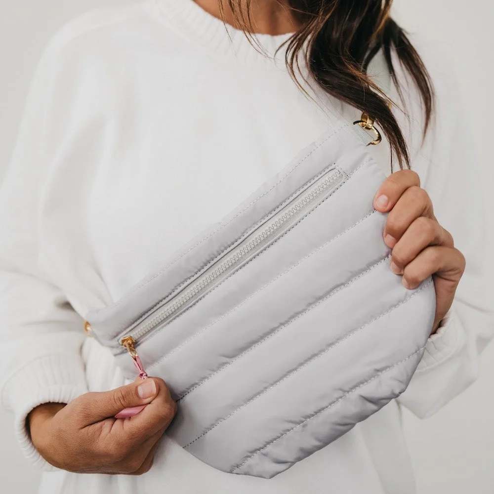 Jolie Puffer Bum Bag Grey  - * Adjustable waist / shoulder strap up to 45 inches. Starts at 27 inches.   * Exterior zipper pocket for easy access to your credit cards and ID and phone Black and white striped lining.   * Bag measures 12" x 8" at the longest points.   * Main material: Quilted Puffer Polyester; Other: Sponge and poly/cotton liner   * Spot Clean  