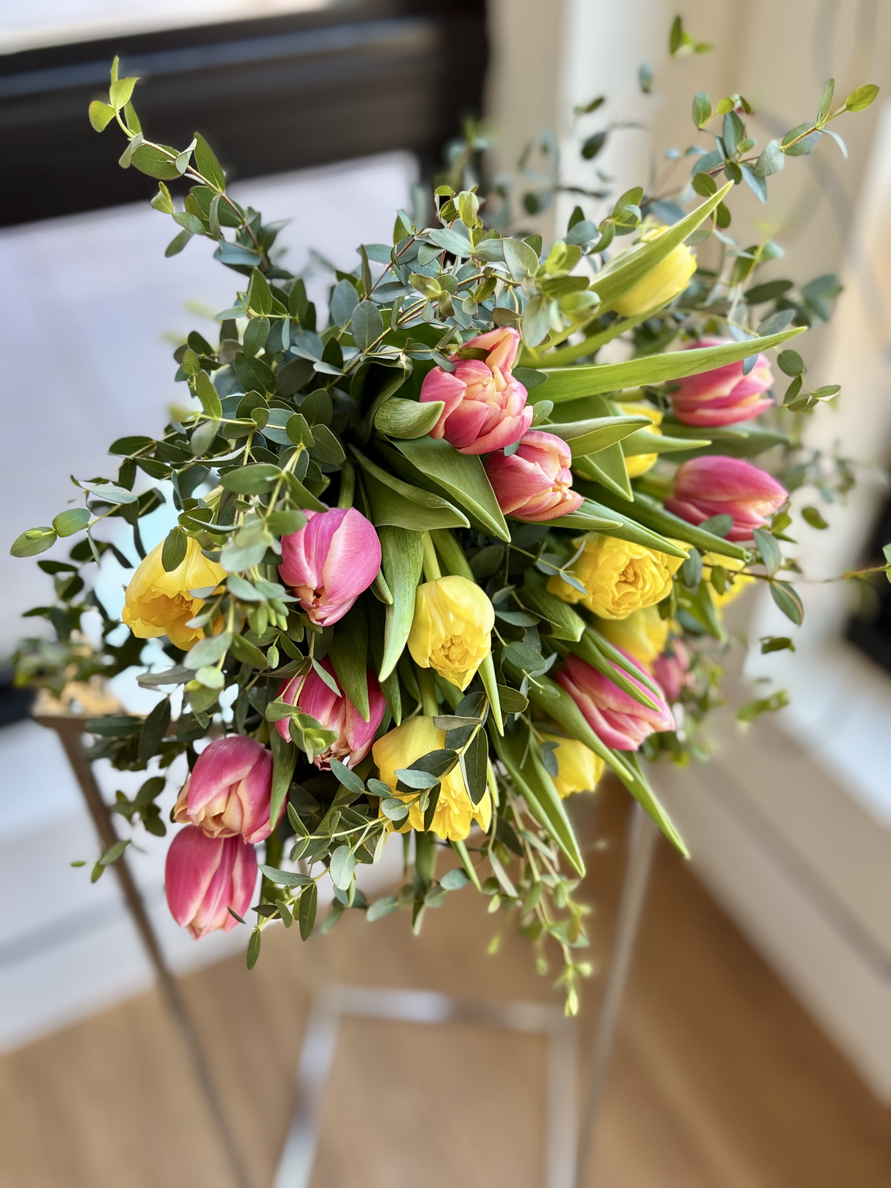 Bouquet of pink and yellow tulips with greenery