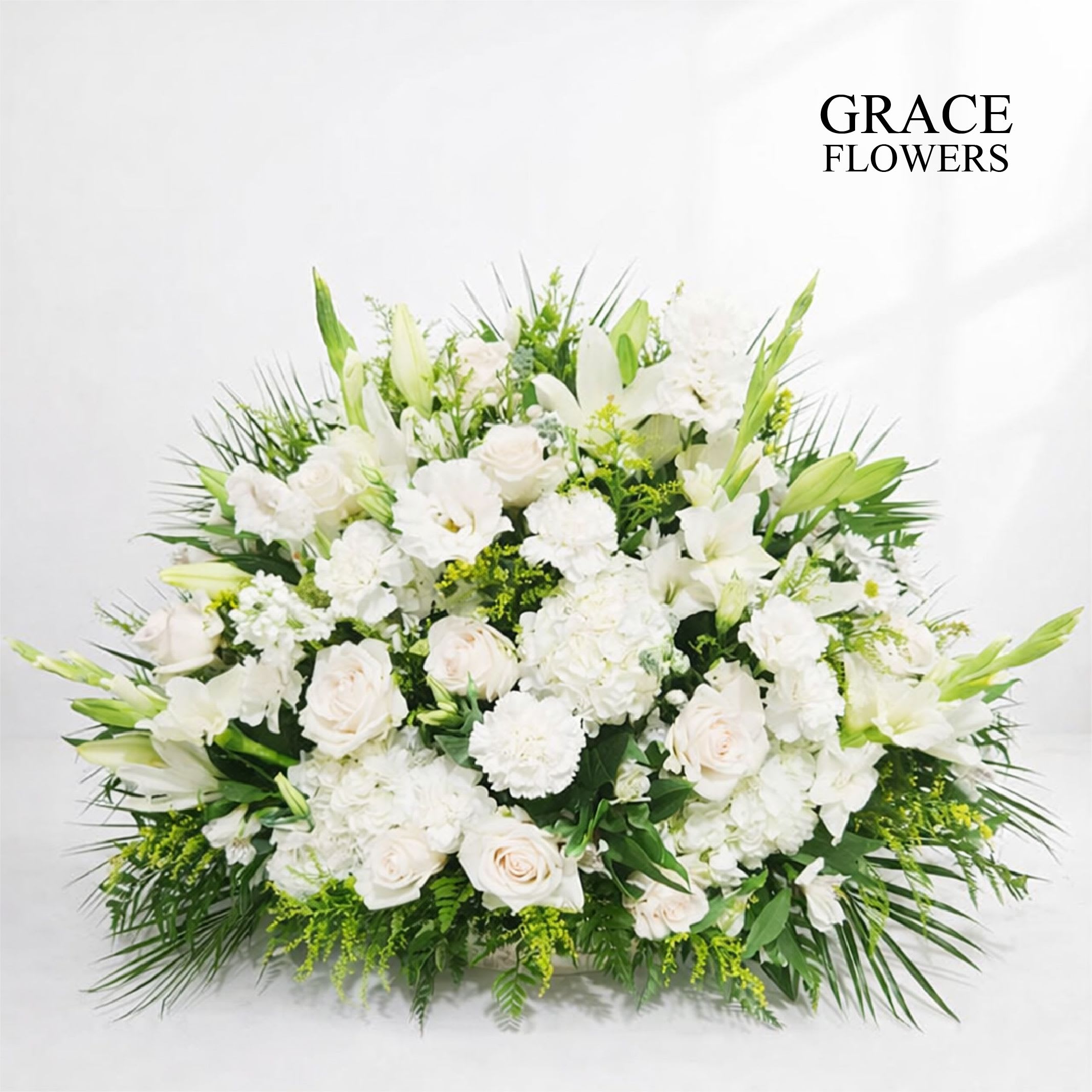 Large white floral arrangement with lilies and roses