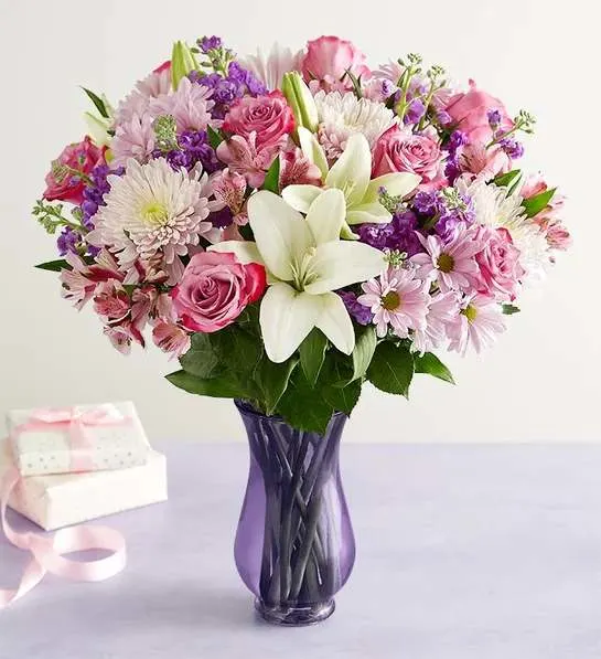 Pink and white mixed bouquet in a purple glass vase
