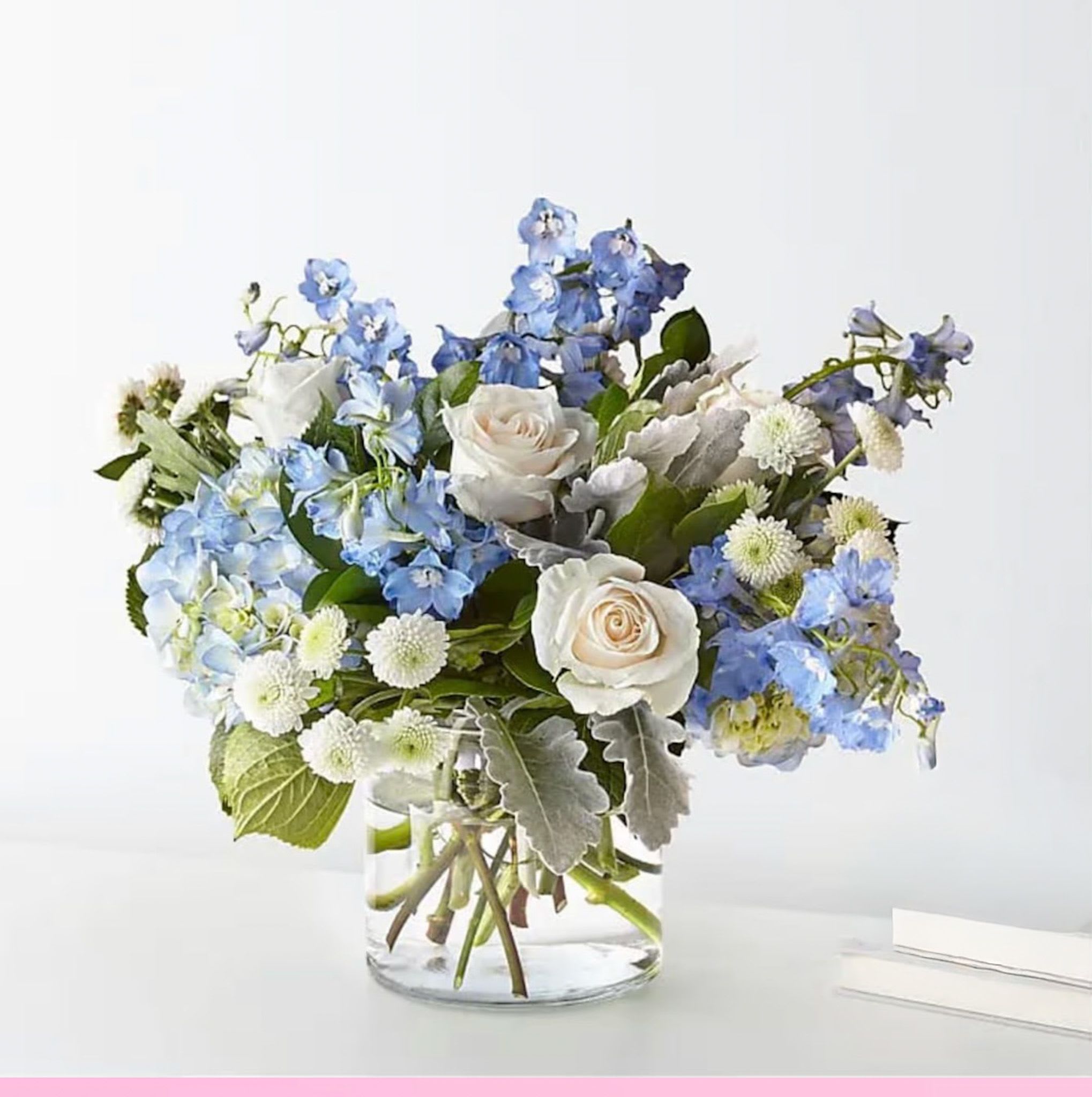 Blue and white flower arrangement in a clear glass vase