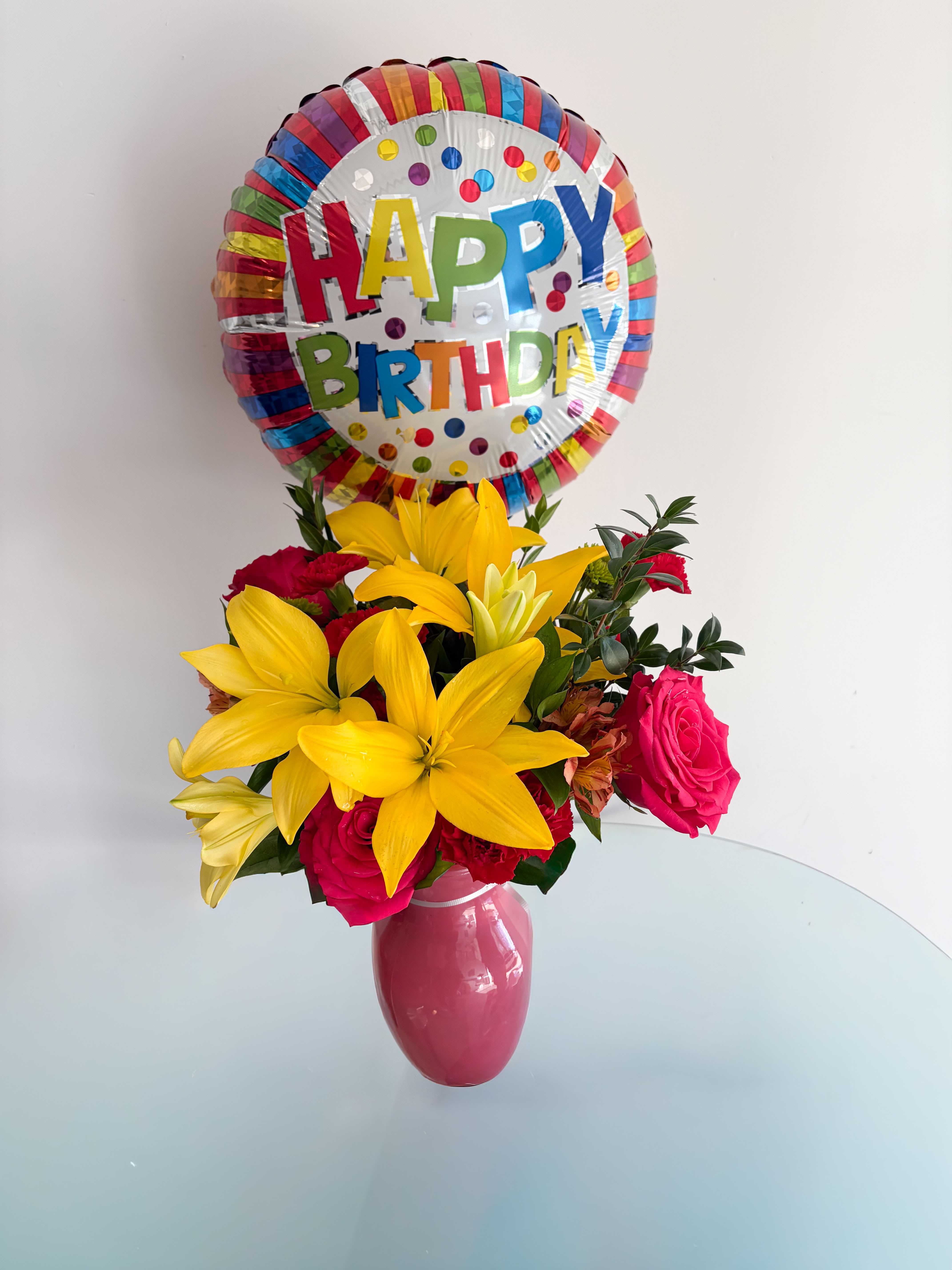 Celebration Bouquet  - including Hot pink roses, Yellow lilies, Orange alstroemeria, Red carnations, and a birthday balloon.