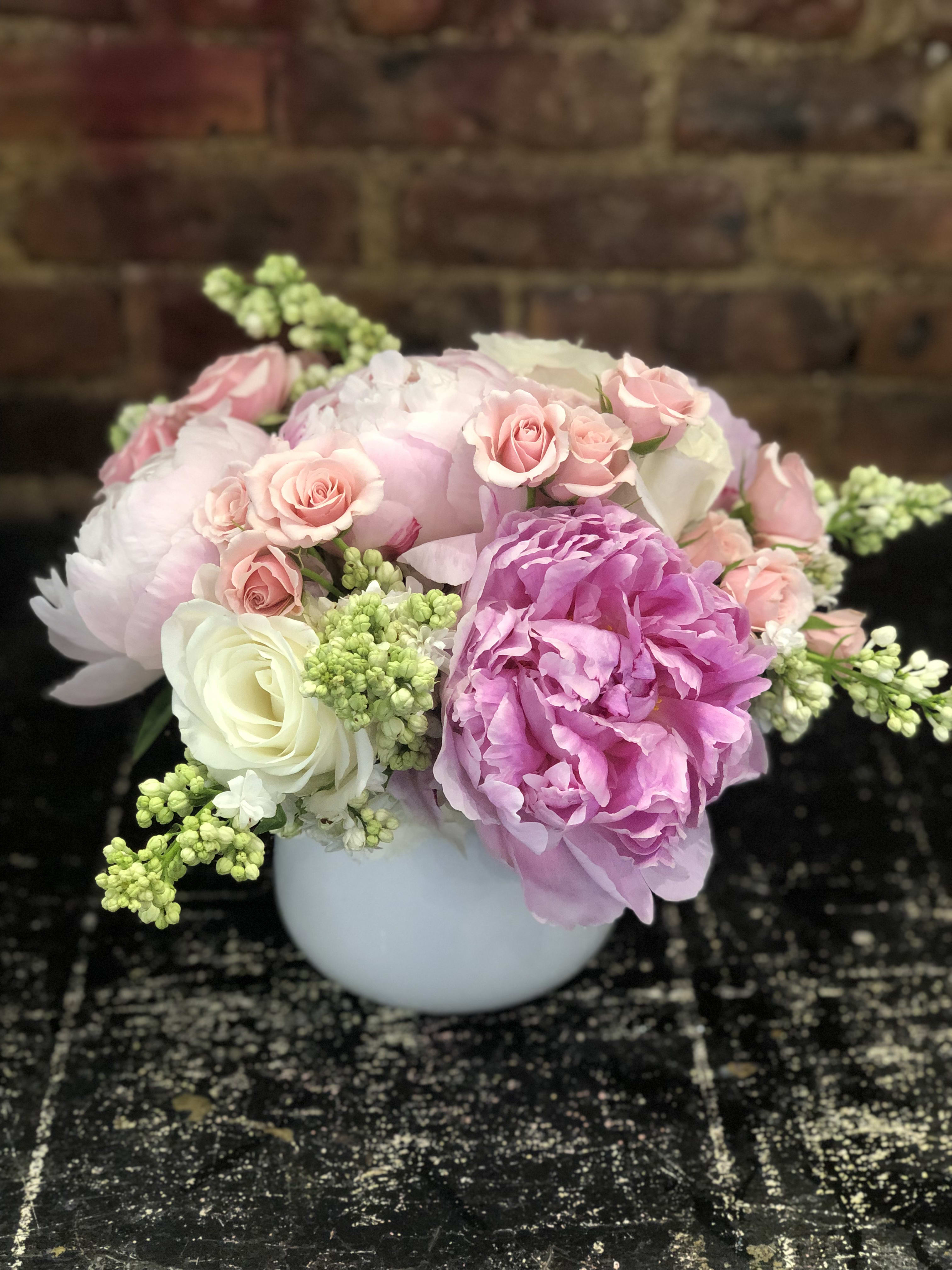 Pink and white floral arrangement in a white vase