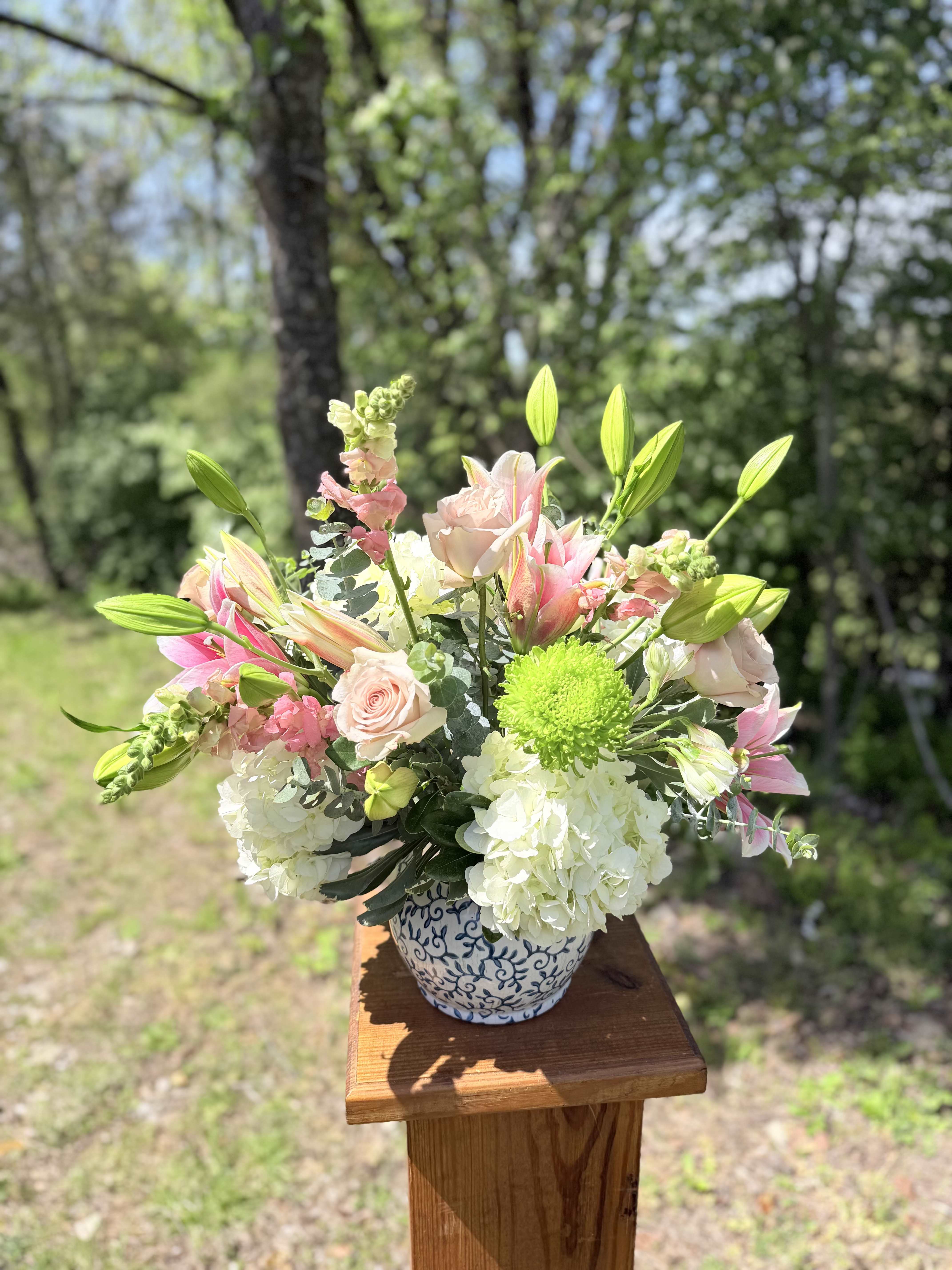 Blue Garden Serenade - Soft pink roses, elegant lilies, white hydrangeas, and fresh green chrysanthemums are gathered in a lush, garden-style arrangement. Designed in a blue-patterned ceramic vase, this bouquet blends gentle pastels with crisp greens for a look that’s both soothing and sophisticated. Ideal for birthdays, thank-yous, or simply adding a touch of refined beauty to any space.