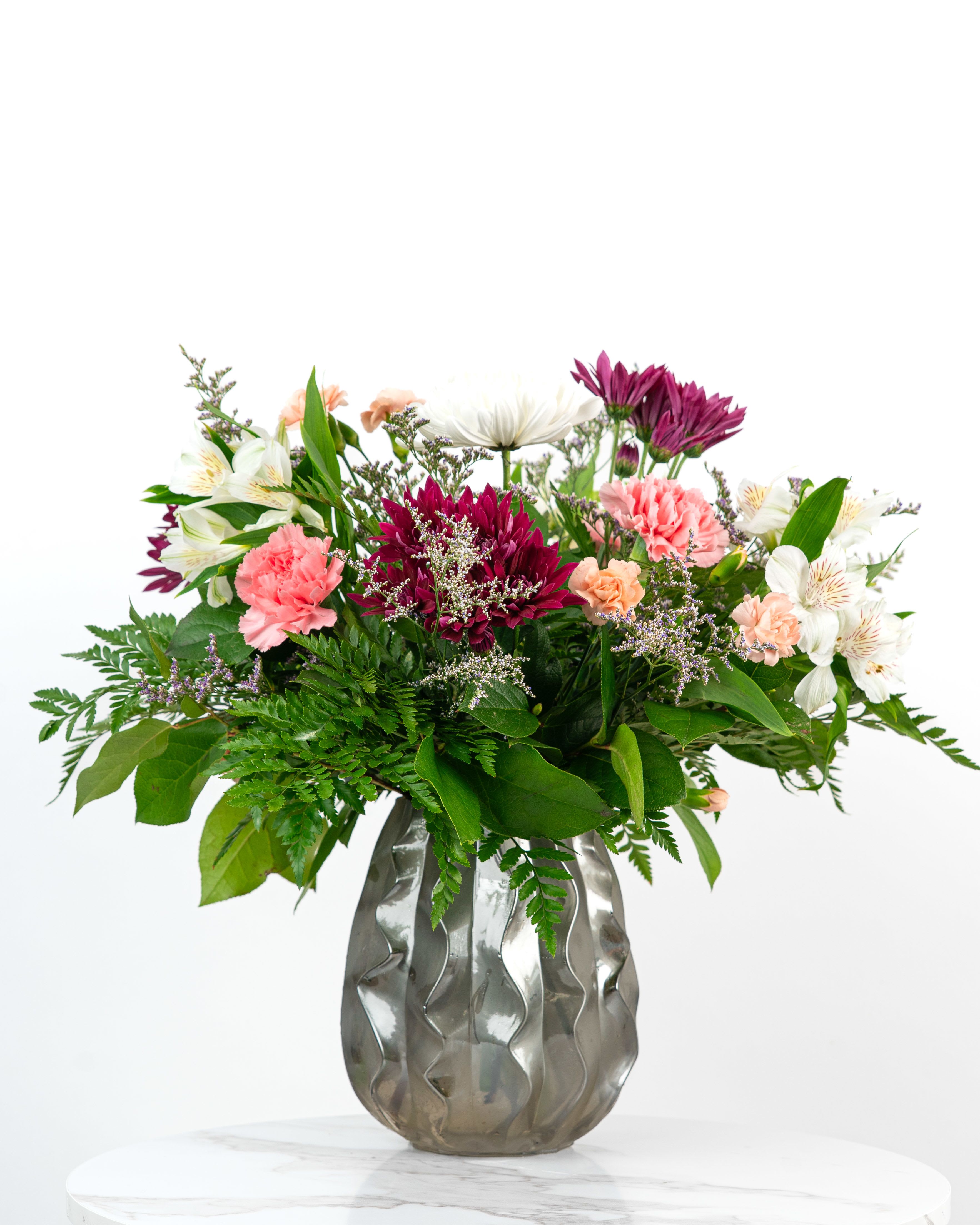 Mixed bouquet in a silver vase with pink, white, and purple flowers