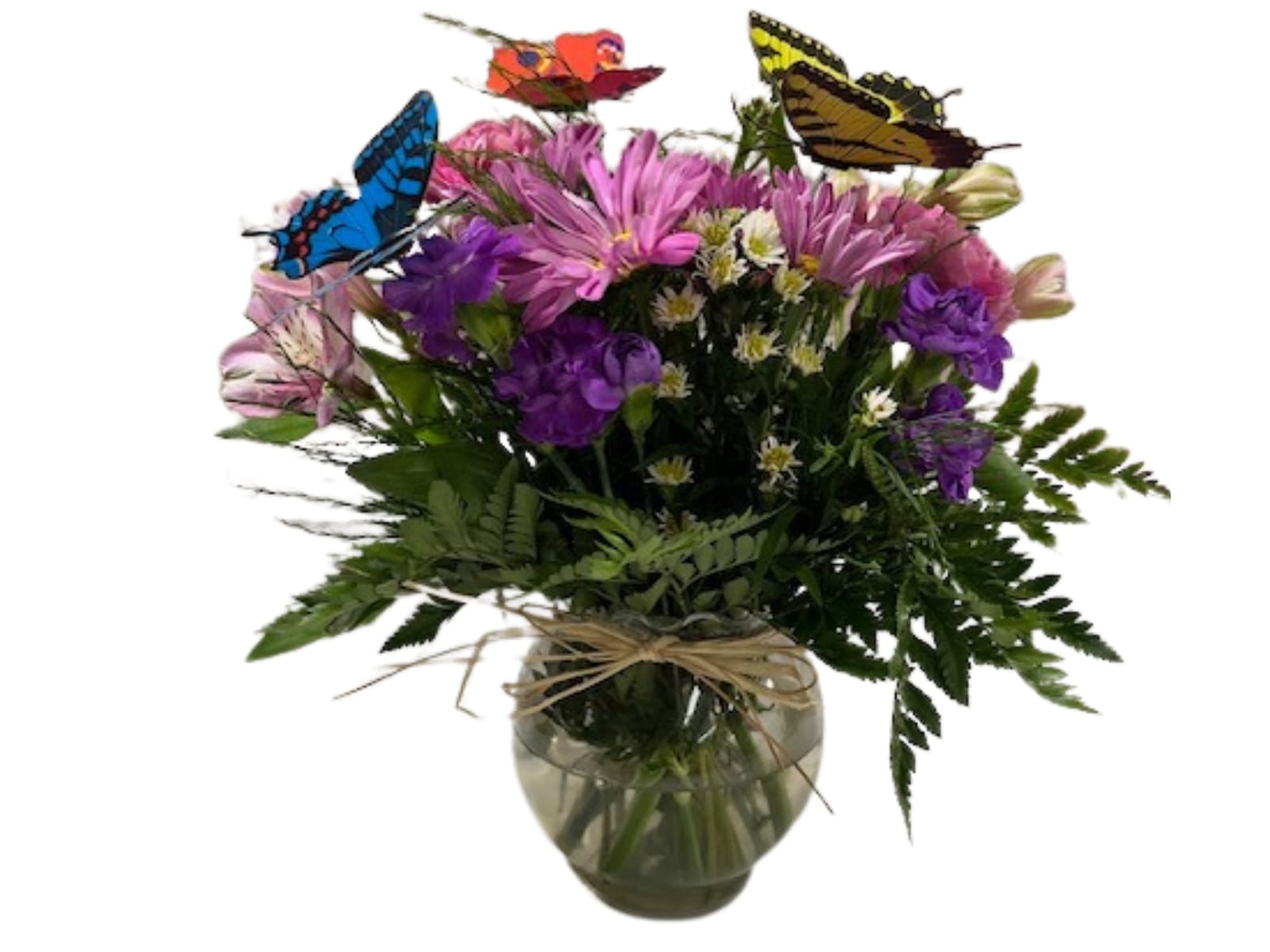 Mixed bouquet of purple and pink flowers in a glass vase with butterfly picks