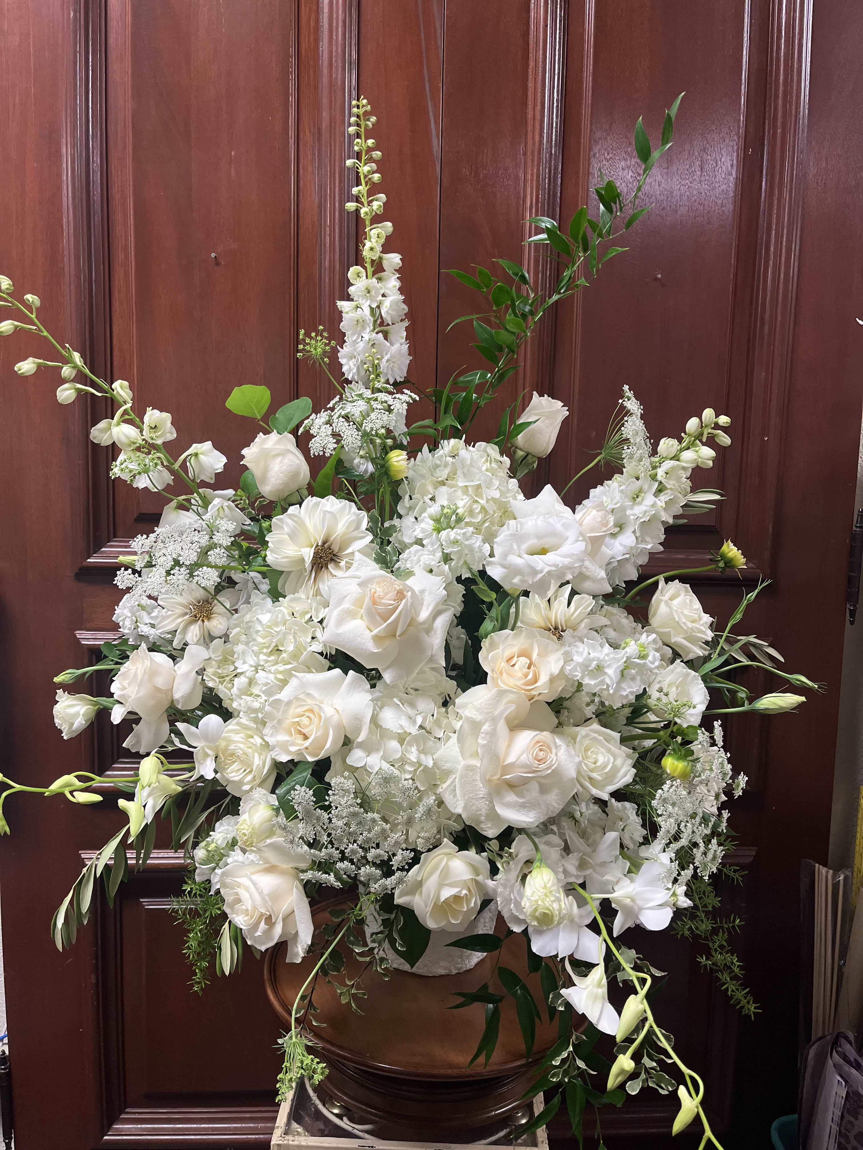 Provence Blanc - Recipe: All-white premium flowers including Delphinium, Hydrangae, Stock, Lisianthus, Roses, Dendrobium Orchids, Dahlias, Queen and Lace, and more in a tall white container. Seasonal: Seasonal Dahlias Orientation: Front Facing View Photo shown: Standard 