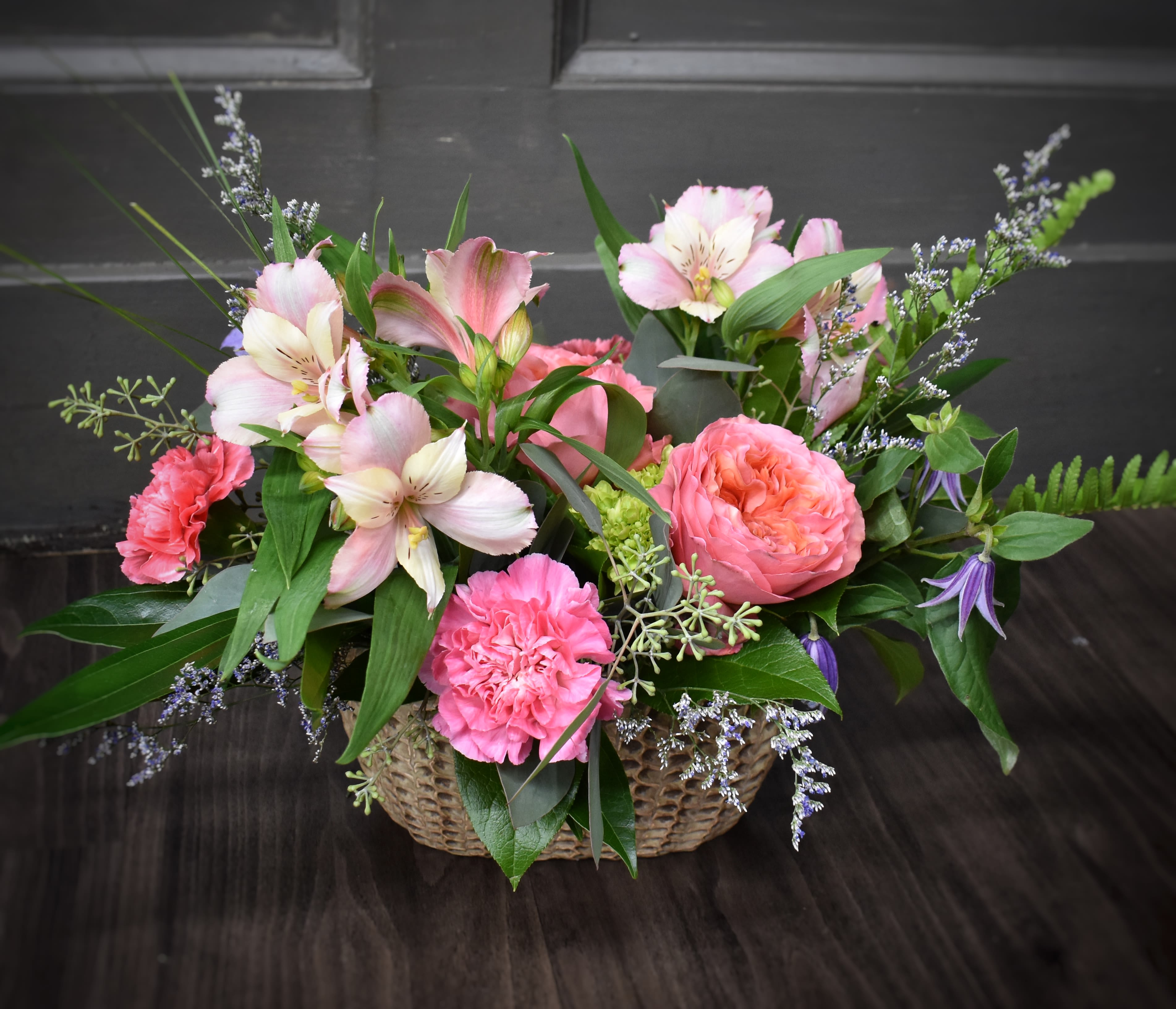 Pink and white flowers arranged in a woven basket